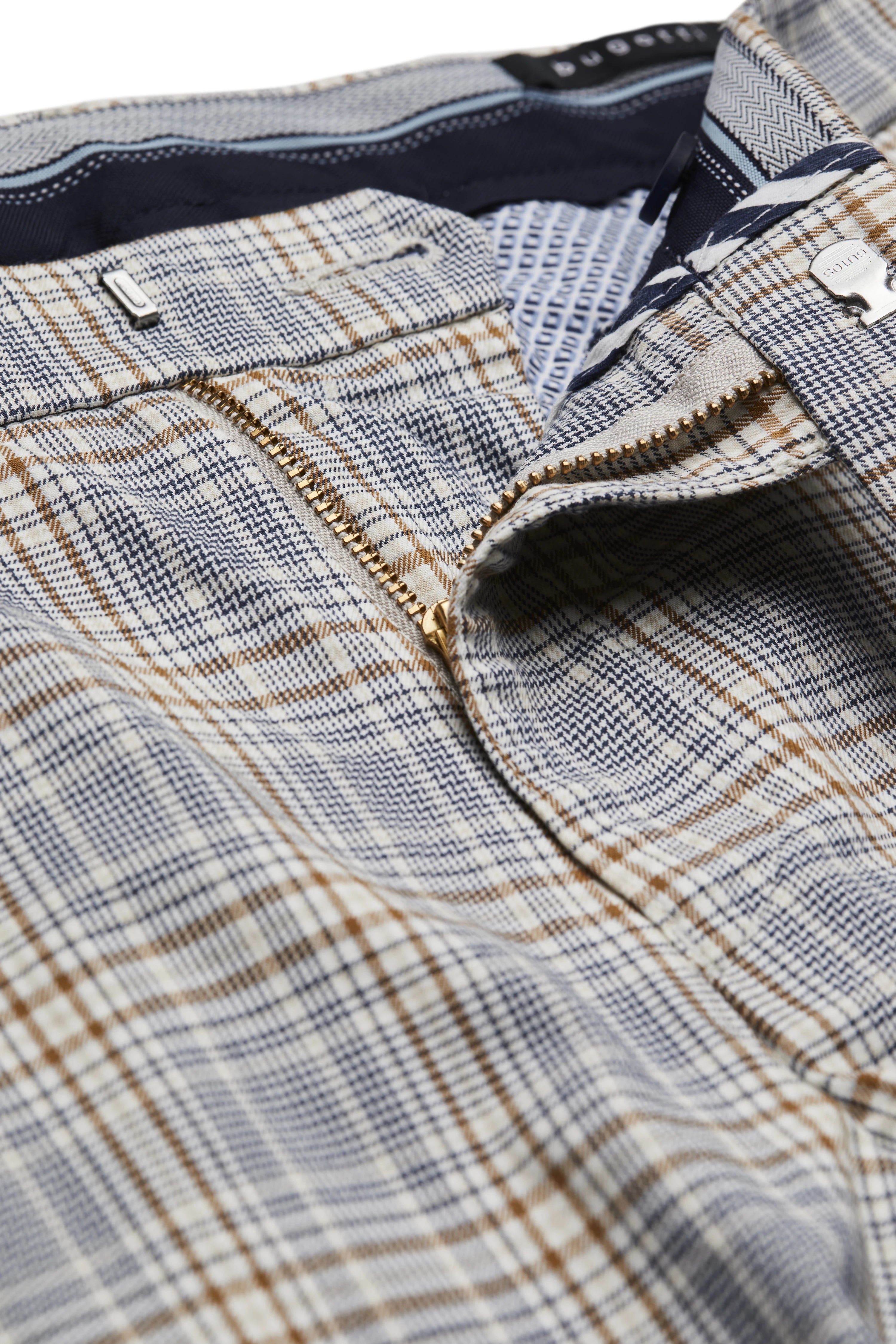 Close-up van een beige-blauwe geruite broek van bugatti met ritssluiting.