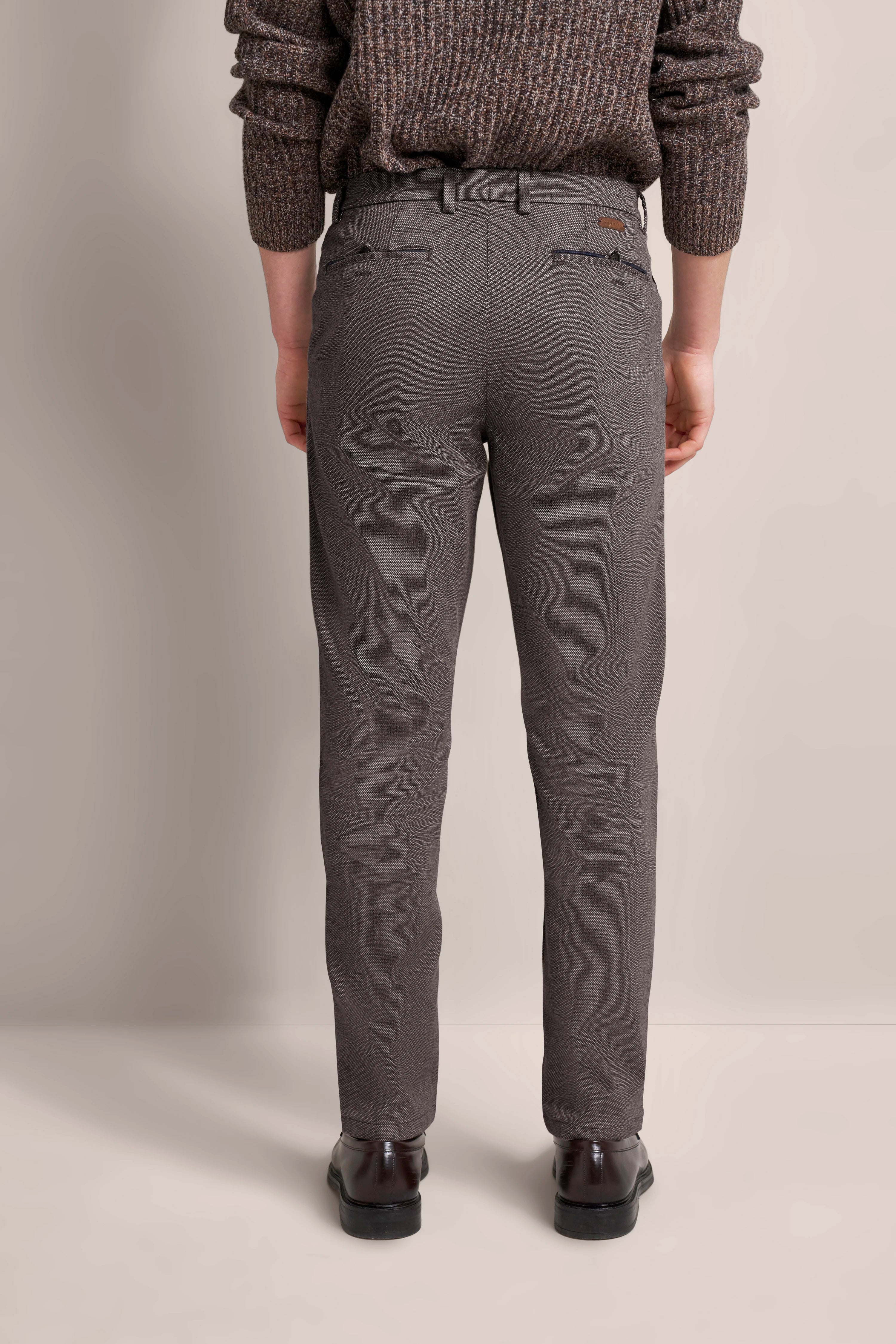 Bugatti Legerbild: graue Hose mit feinem Muster, braune Schuhe, brauner Strickpullover von hinten.