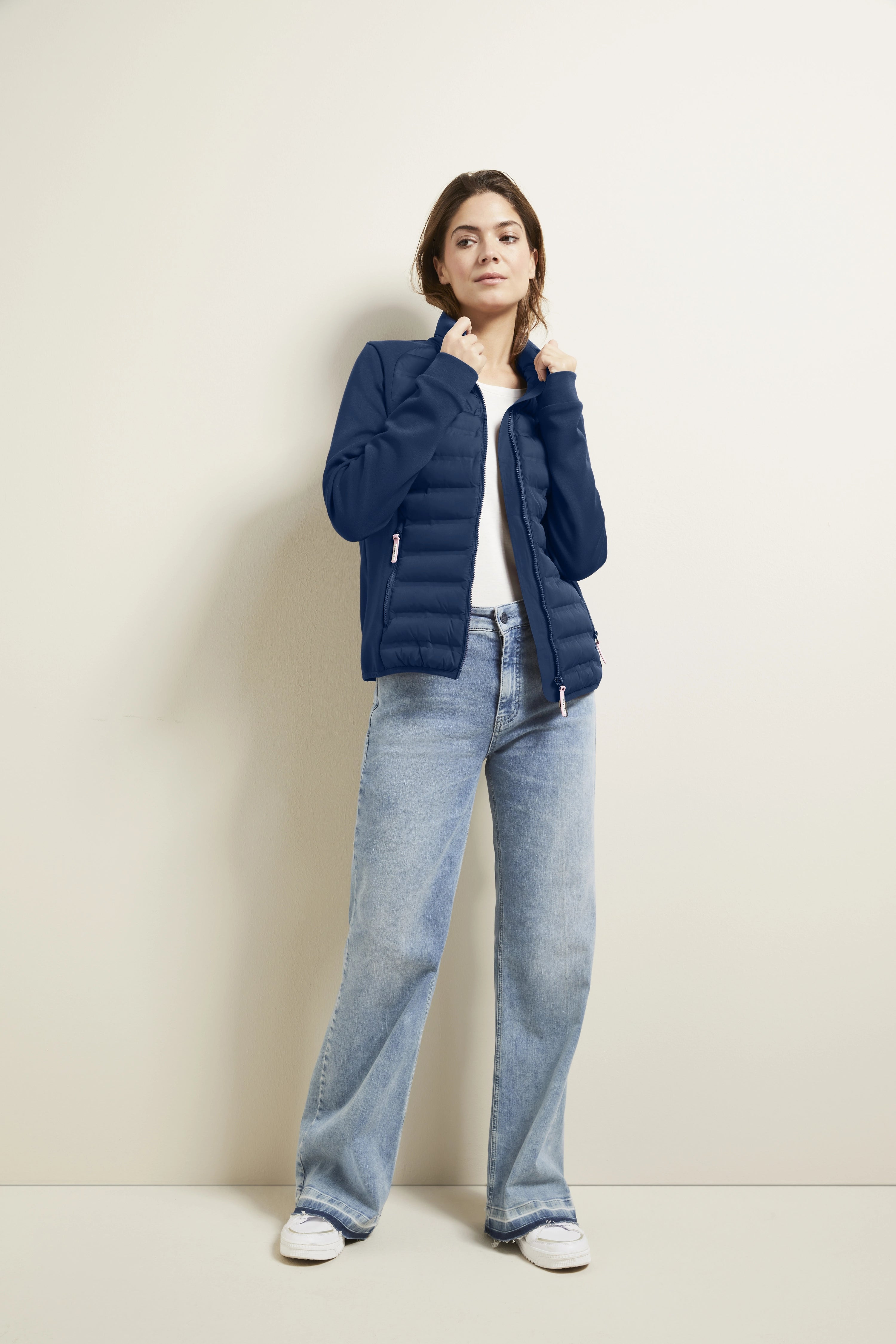 Model in blauwe bugatti jas, wit shirt, lichtblauwe jeans