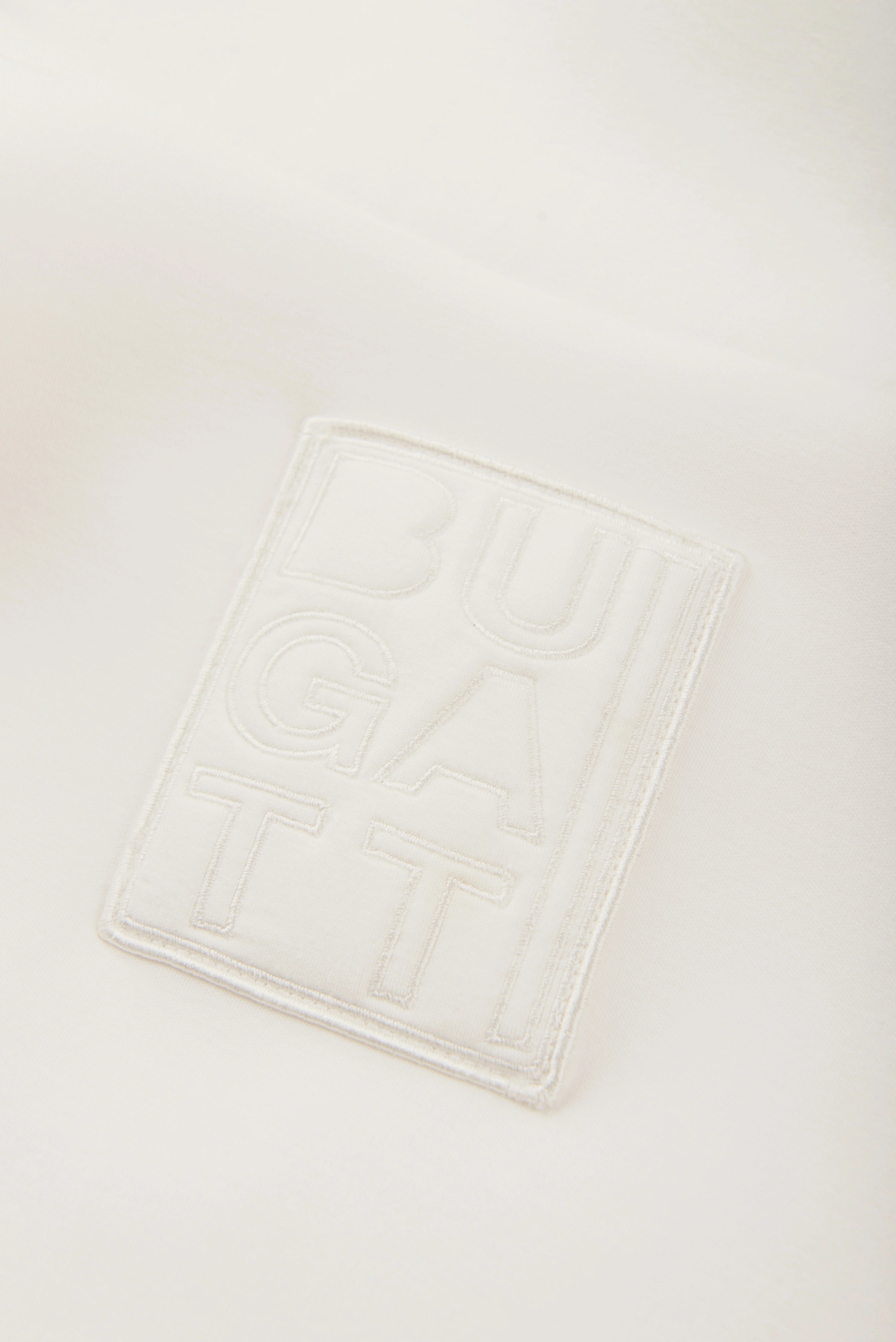 Weißes bugatti-Logo auf Stoff, Detailansicht, schlichtes Design, symbolisiert Eleganz und Qualität.