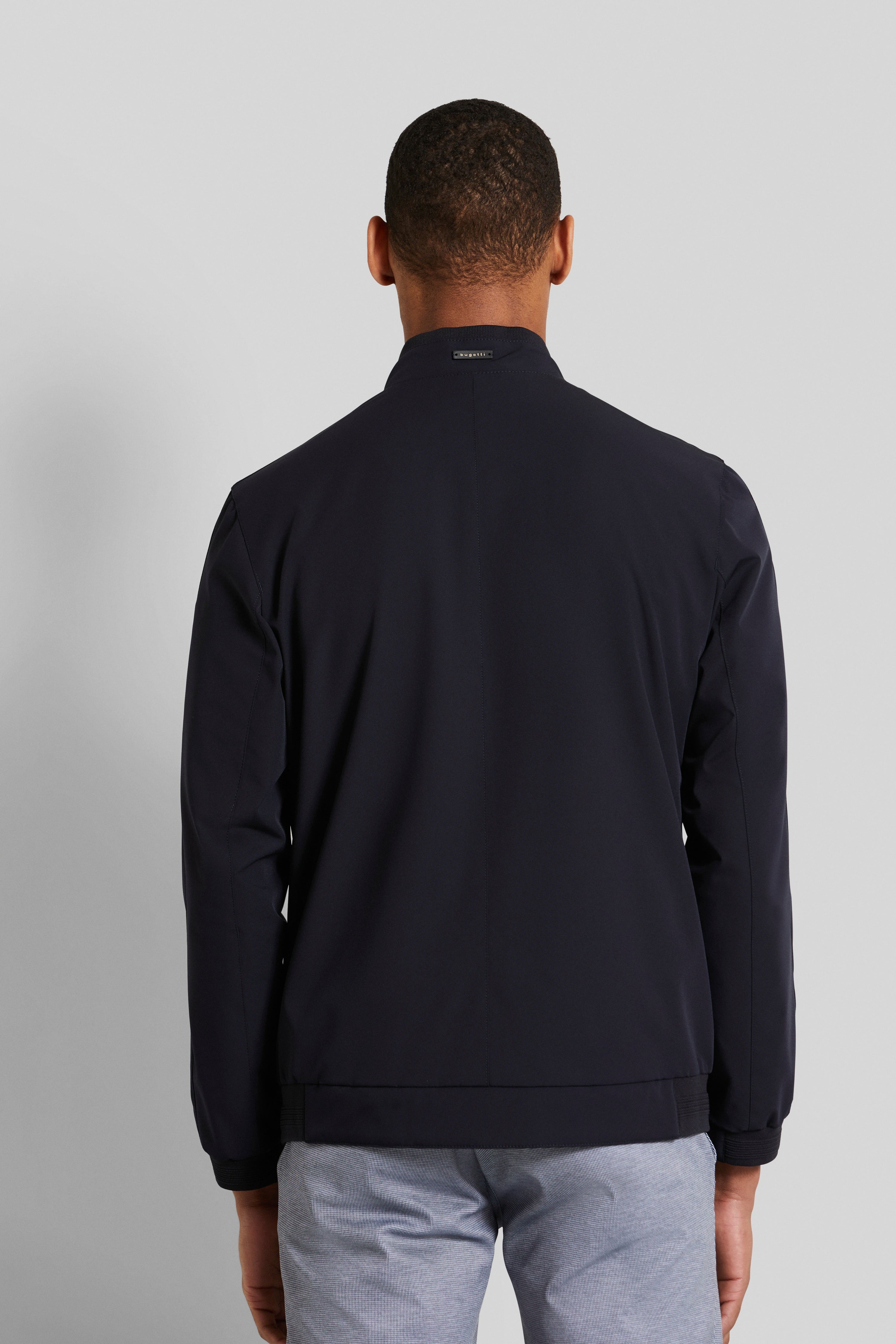 Rückansicht eines Models in dunkelblauer bugatti Jacke und grauer Hose.