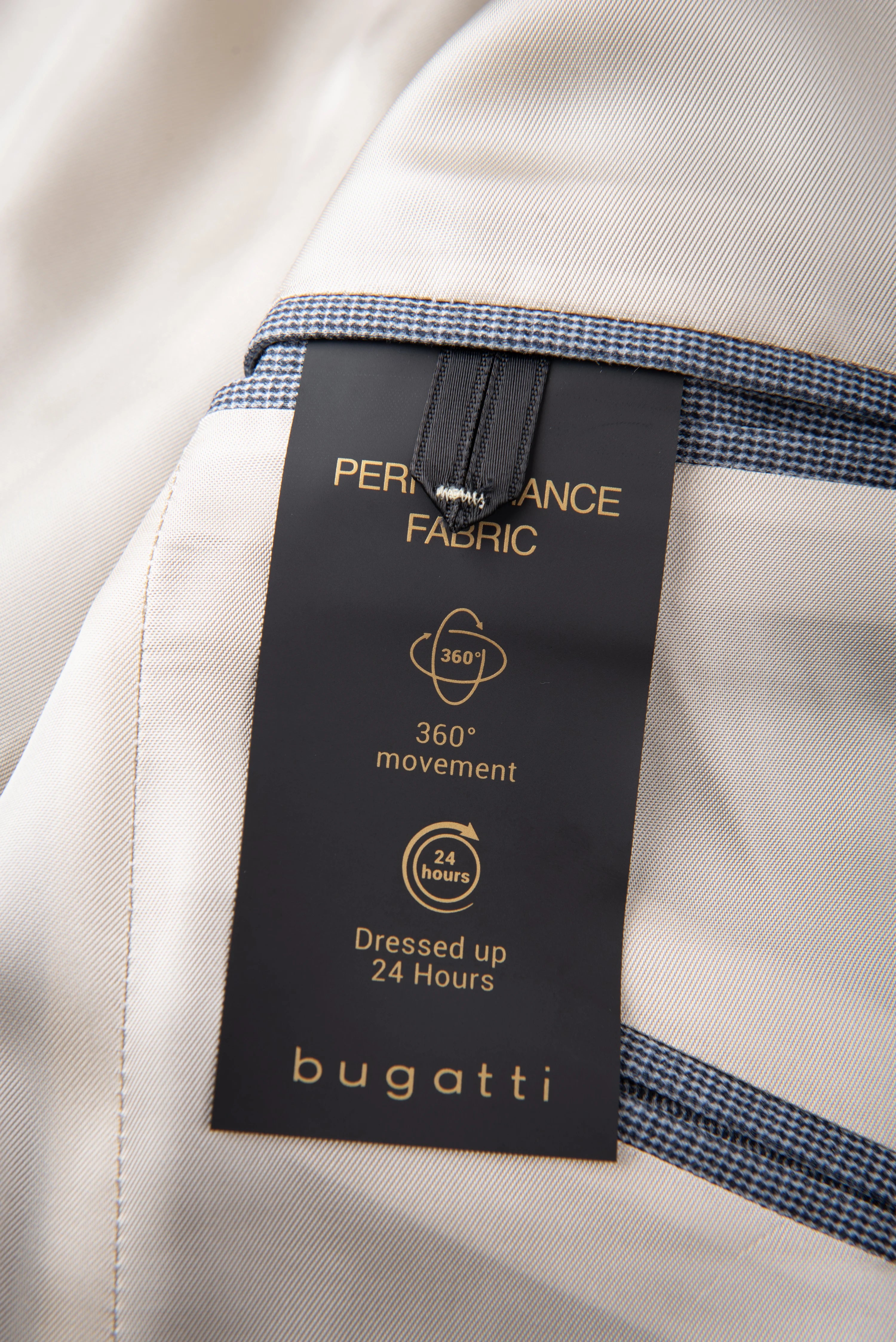 Beige bugatti-jasje met performance-stoflabel en blauwe accenten, gedetailleerde opname.