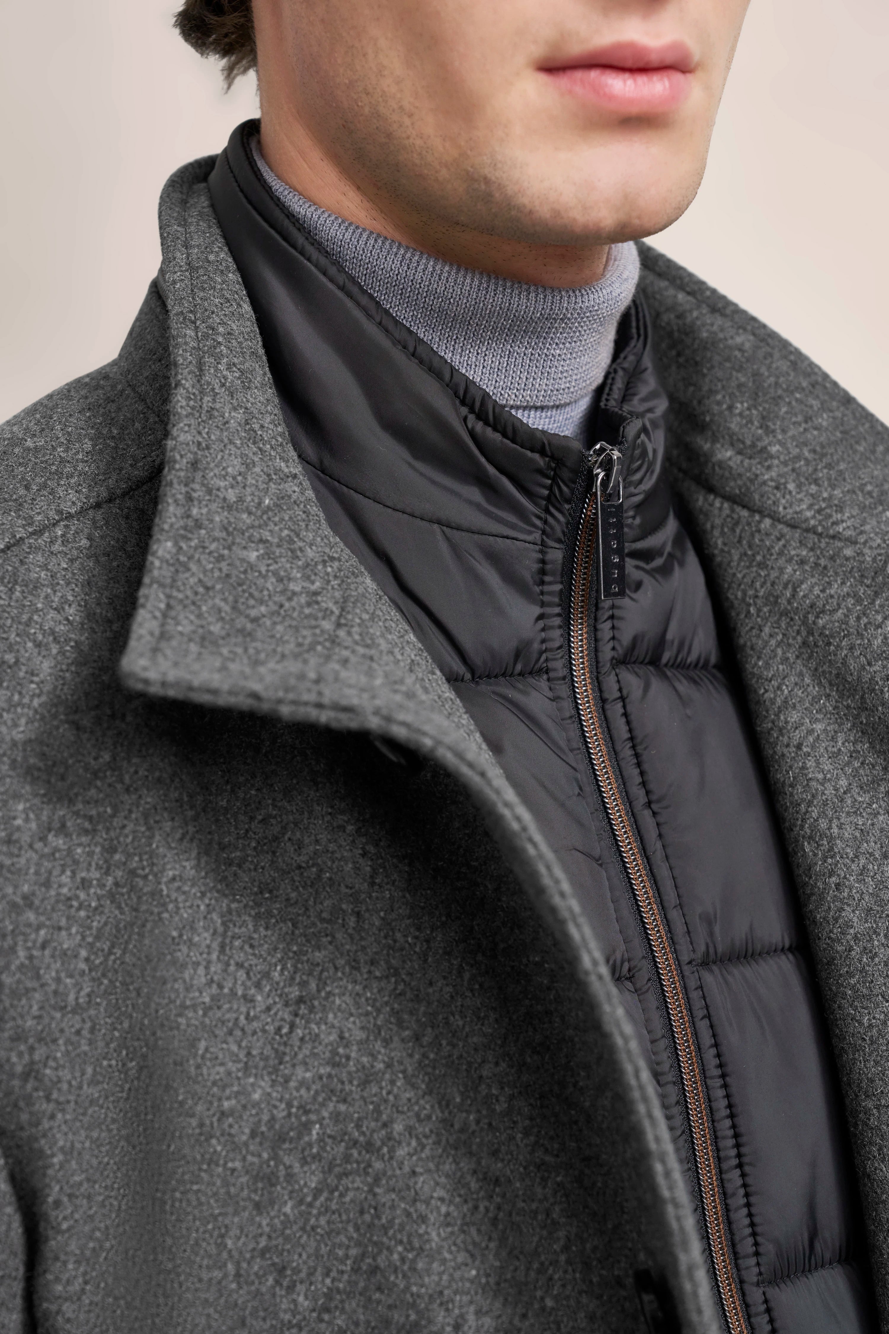 Grauer Wollmantel, schwarze Steppjacke und grauer Rollkragen, Detailaufnahme, bugatti.