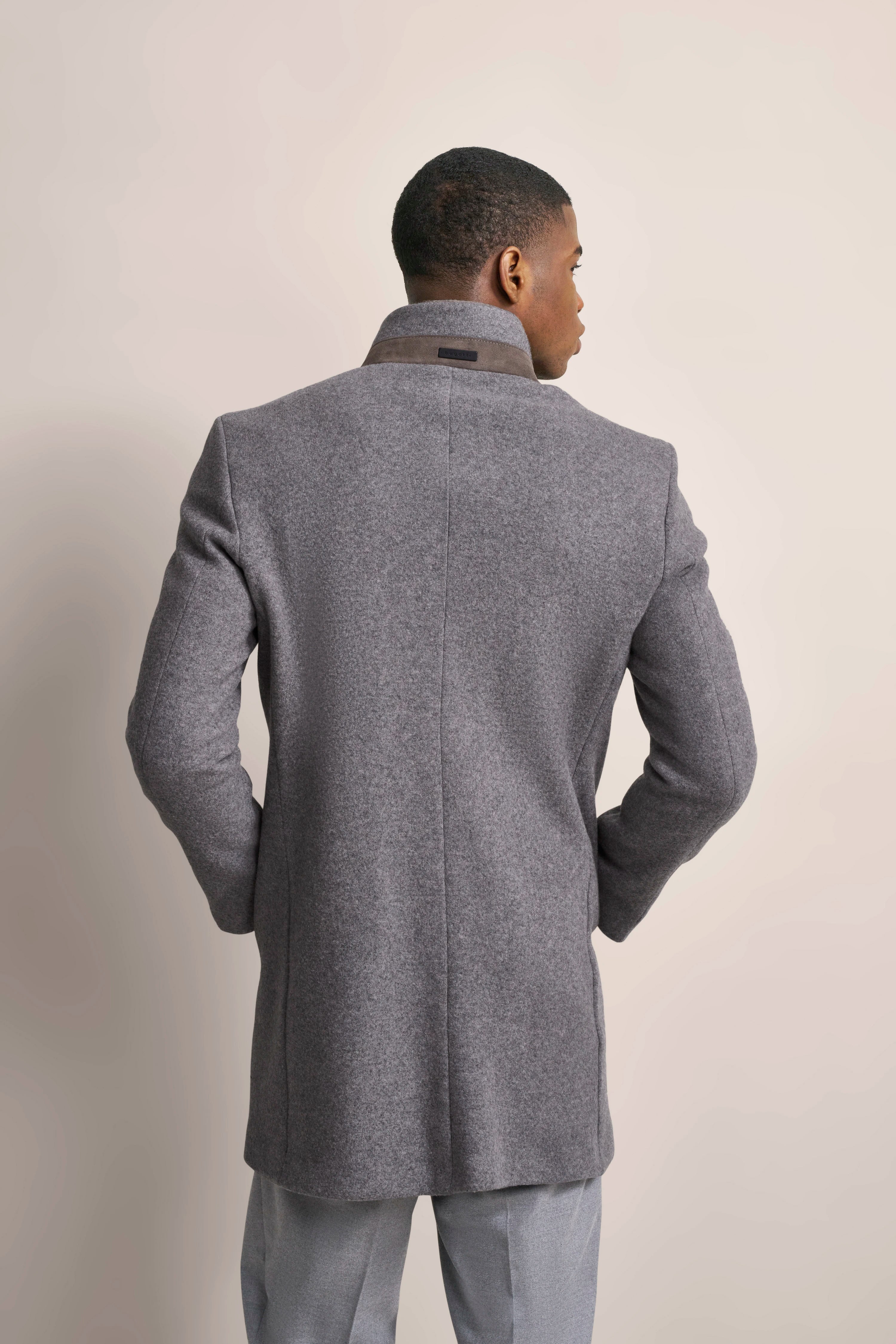 Grauer bugatti Mantel, Rückansicht, getragen von Model, elegant und stilvoll.