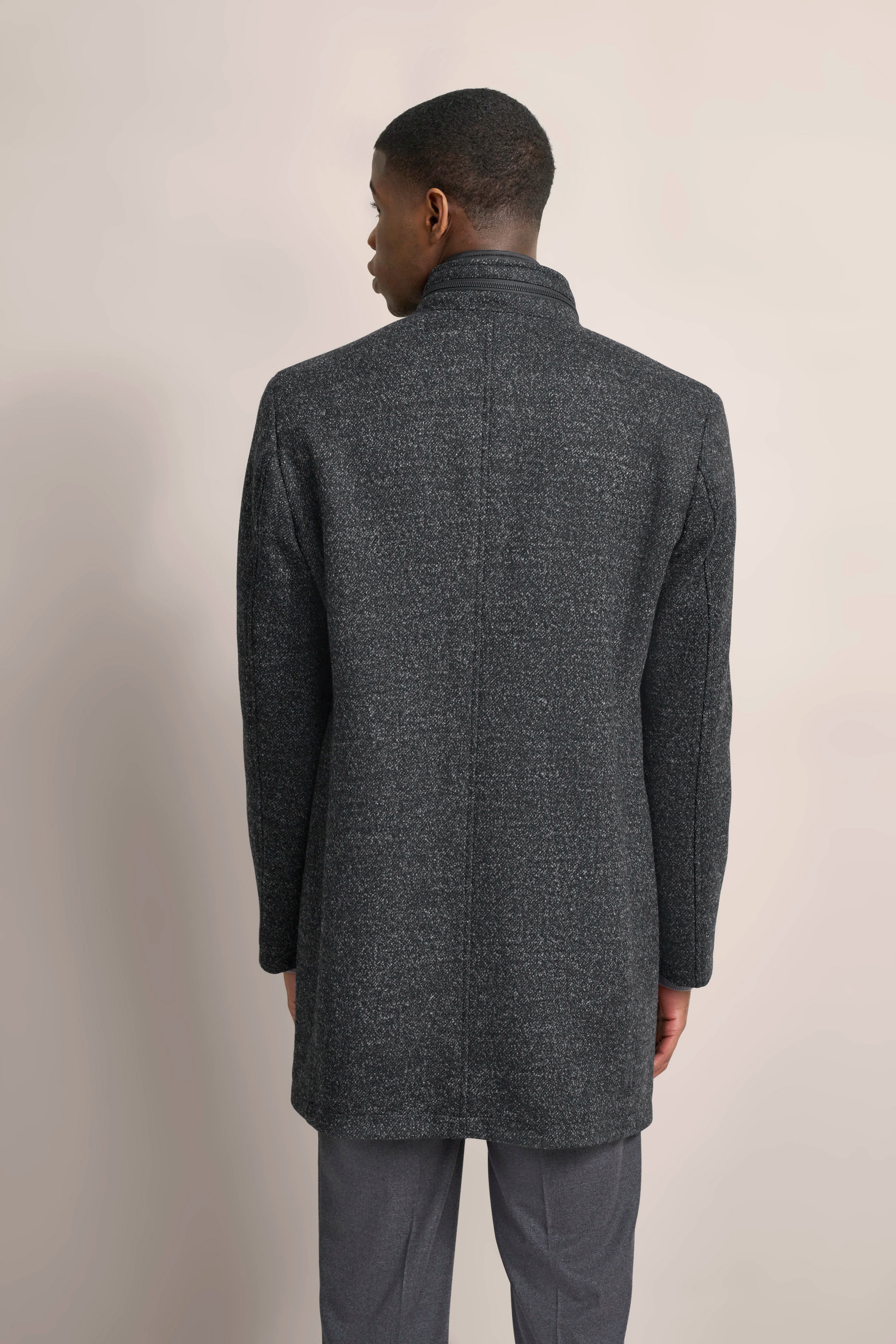 Grauer bugatti Mantel, Rückansicht, getragen von Model, lässige Pose, elegantes Design.