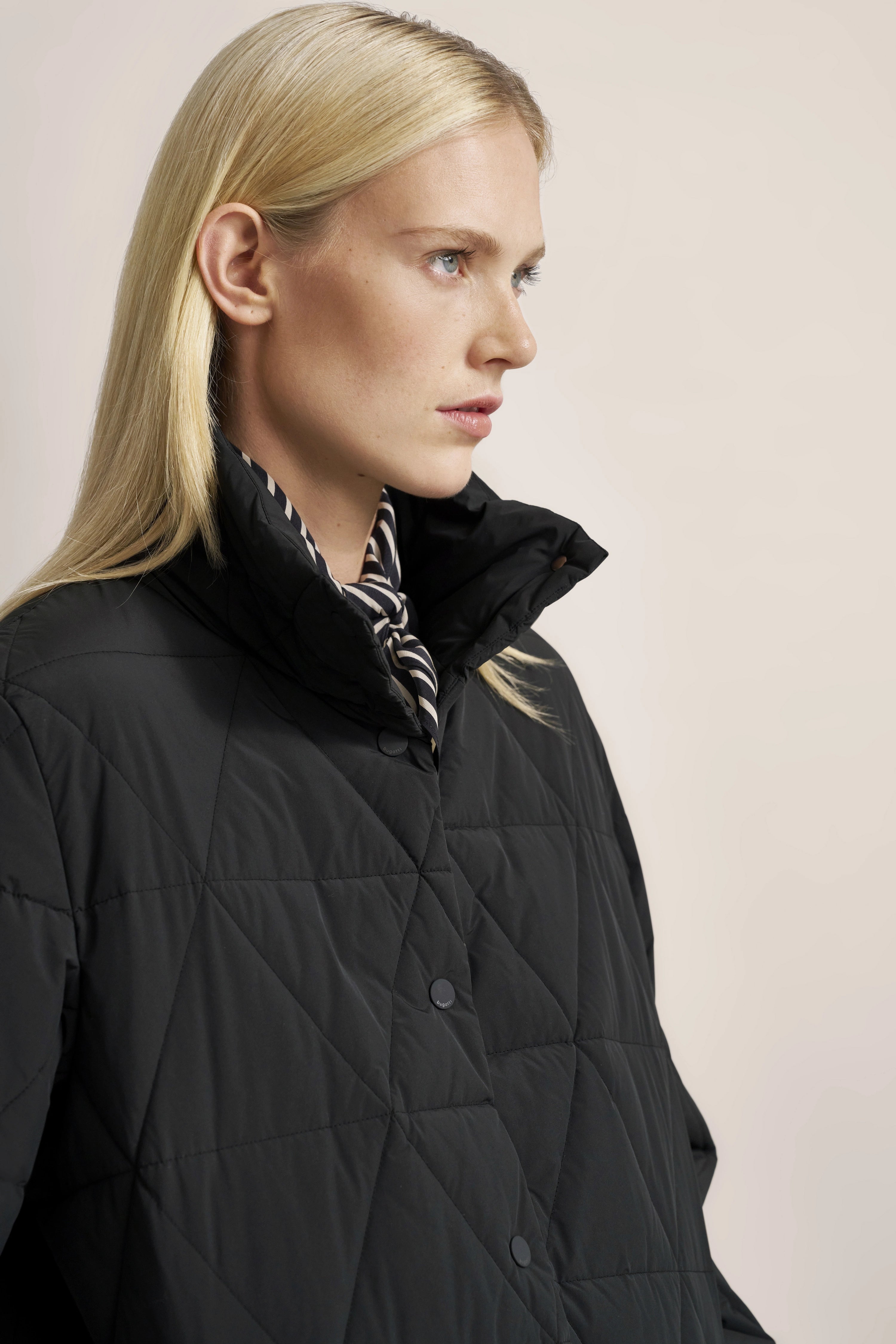 Schwarze Steppjacke von bugatti, Modelbild im Profil, dezente Eleganz und zeitlose Raffinesse.