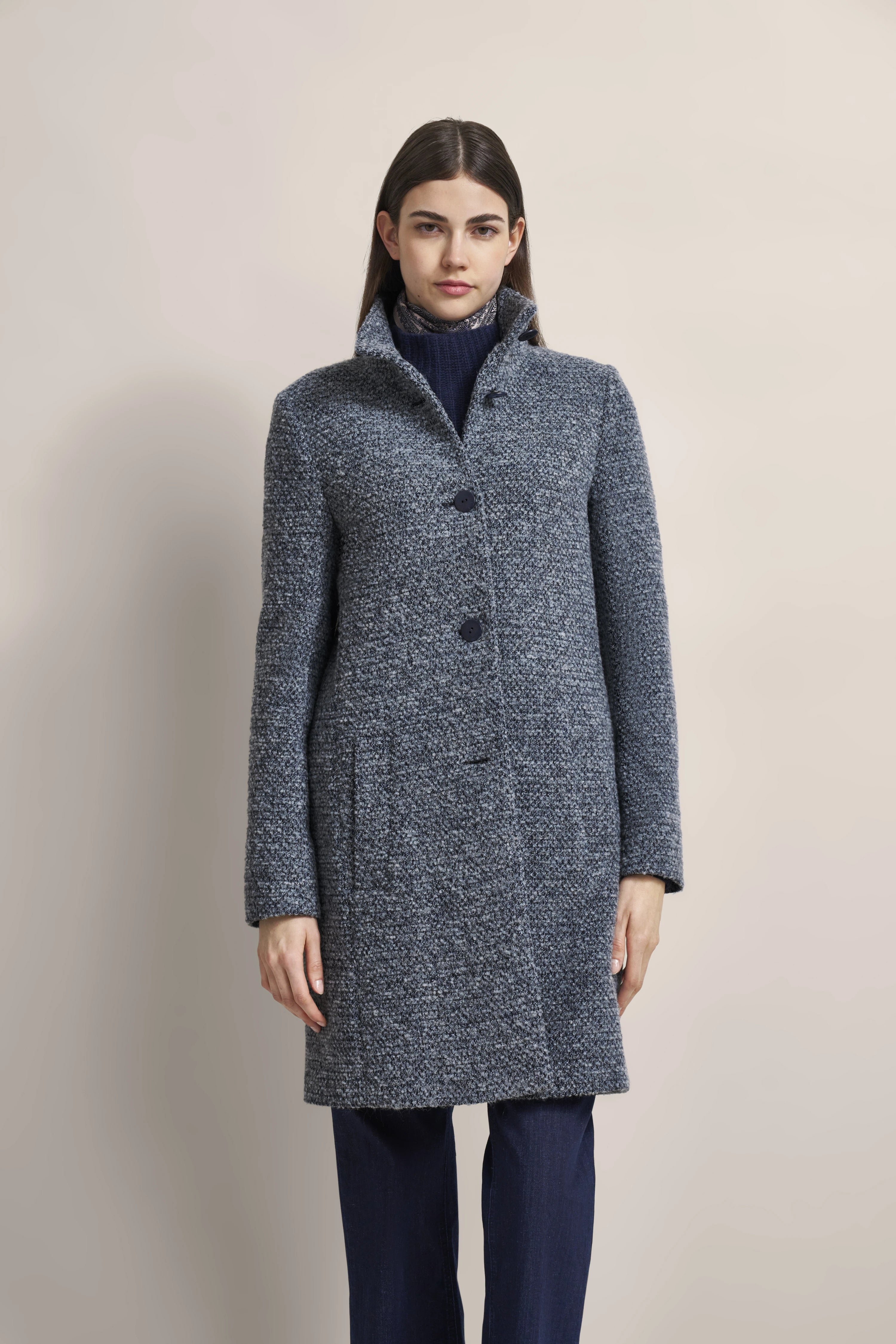 Model in grauem bugatti Mantel mit Knöpfen, dunkelblauem Rollkragenpullover, leger posierend.