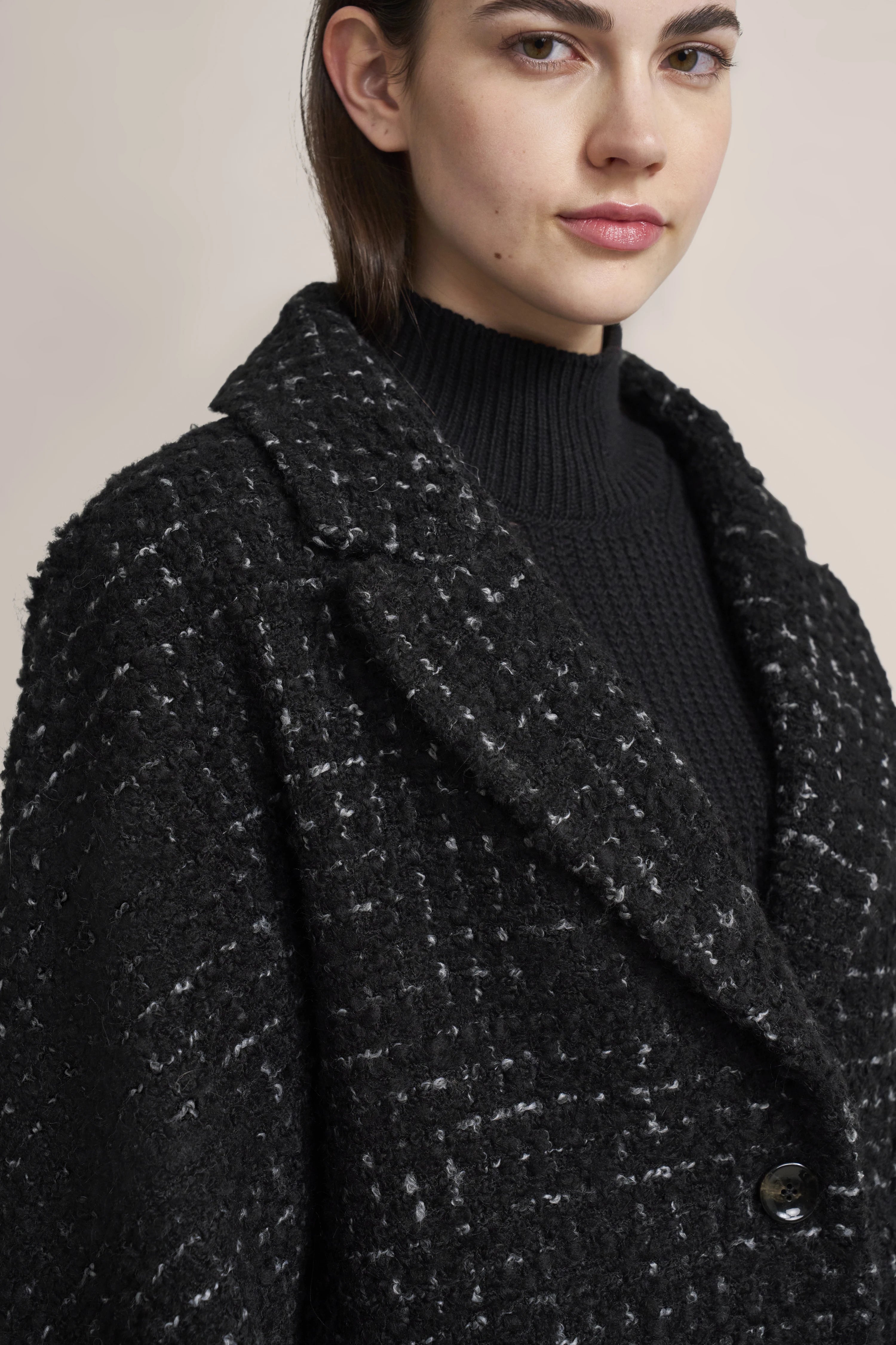 Schwarzer Tweed-Mantel, Modellbild in Nahaufnahme, mit elegantem Posing.