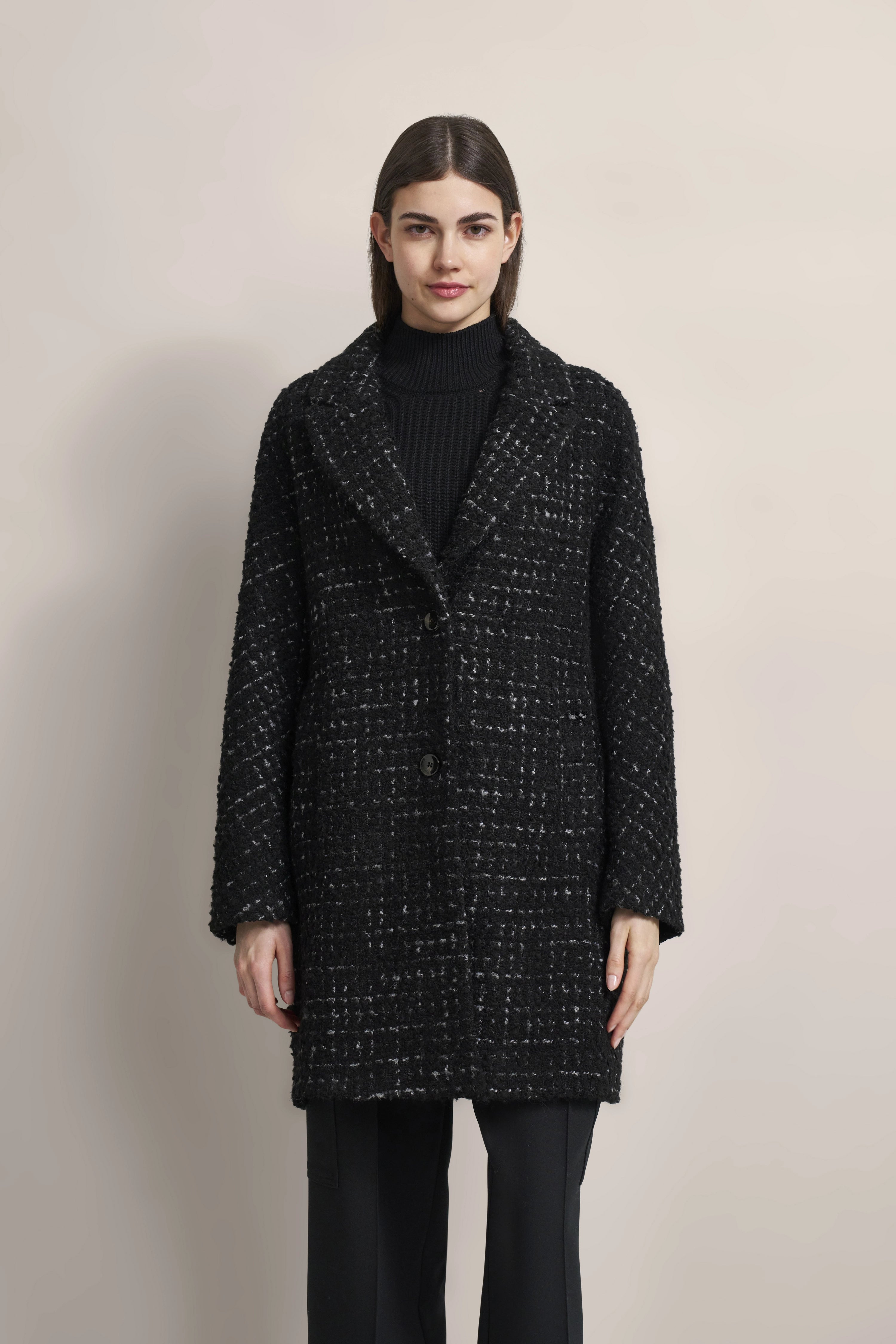 Schwarzer bugatti Mantel mit Strukturmuster, schwarzer Rollkragenpullover, Model posiert frontal.