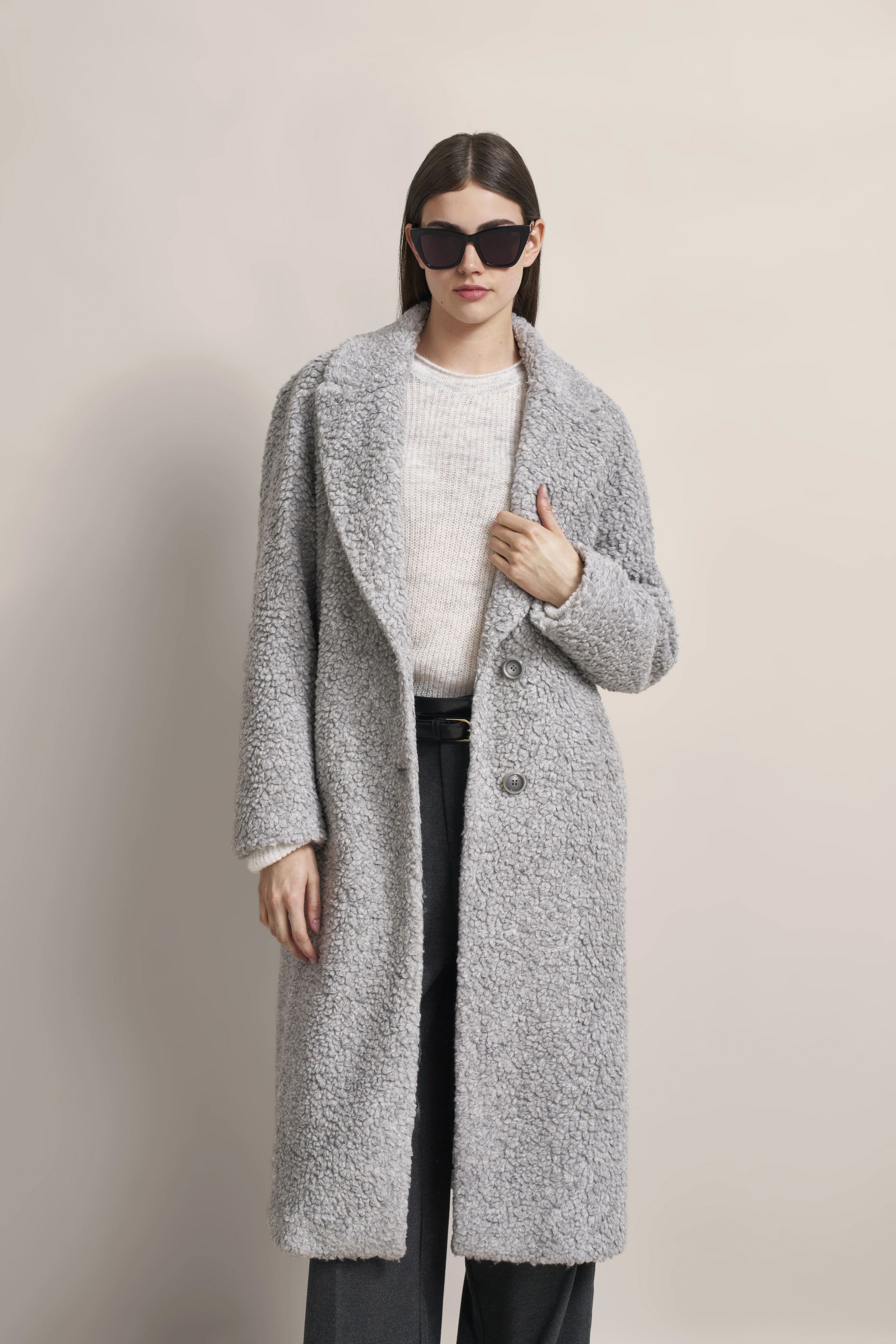 Grauer Mantel, weißer Pullover, schwarze Hose