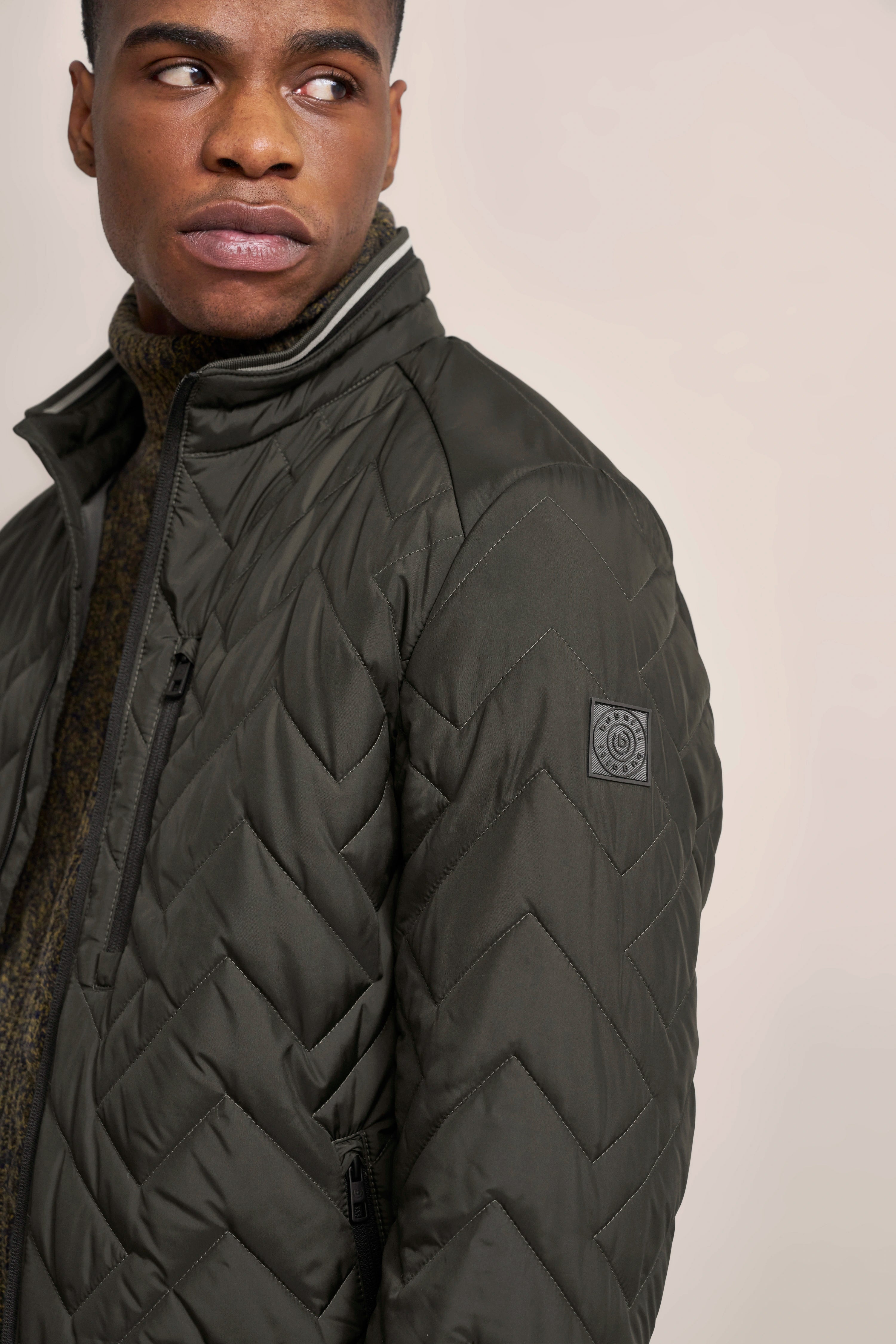 Dunkelgrüne bugatti Jacke, gesteppter Chevron-Muster, Rückansicht, legeres Design, hochwertige Materialien.