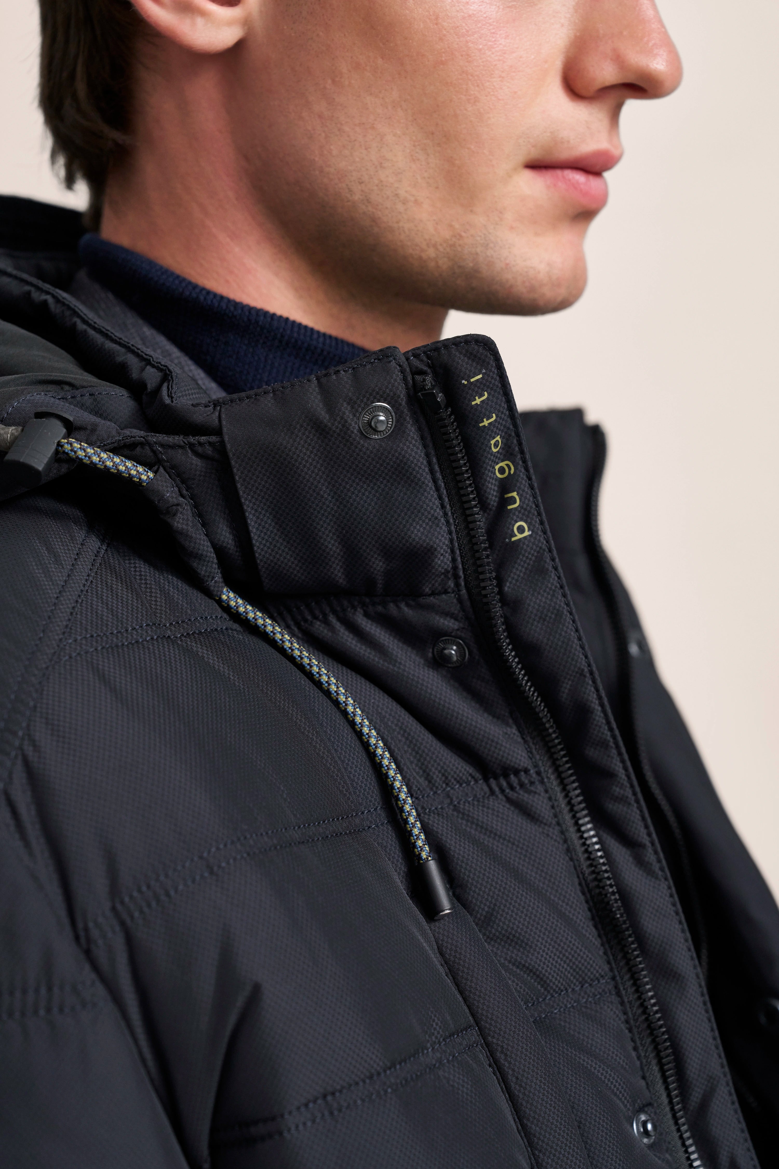 Schwarze bugatti Jacke mit Kapuze, Nahaufnahme, sportlich-klassisches Design, dezente Details.