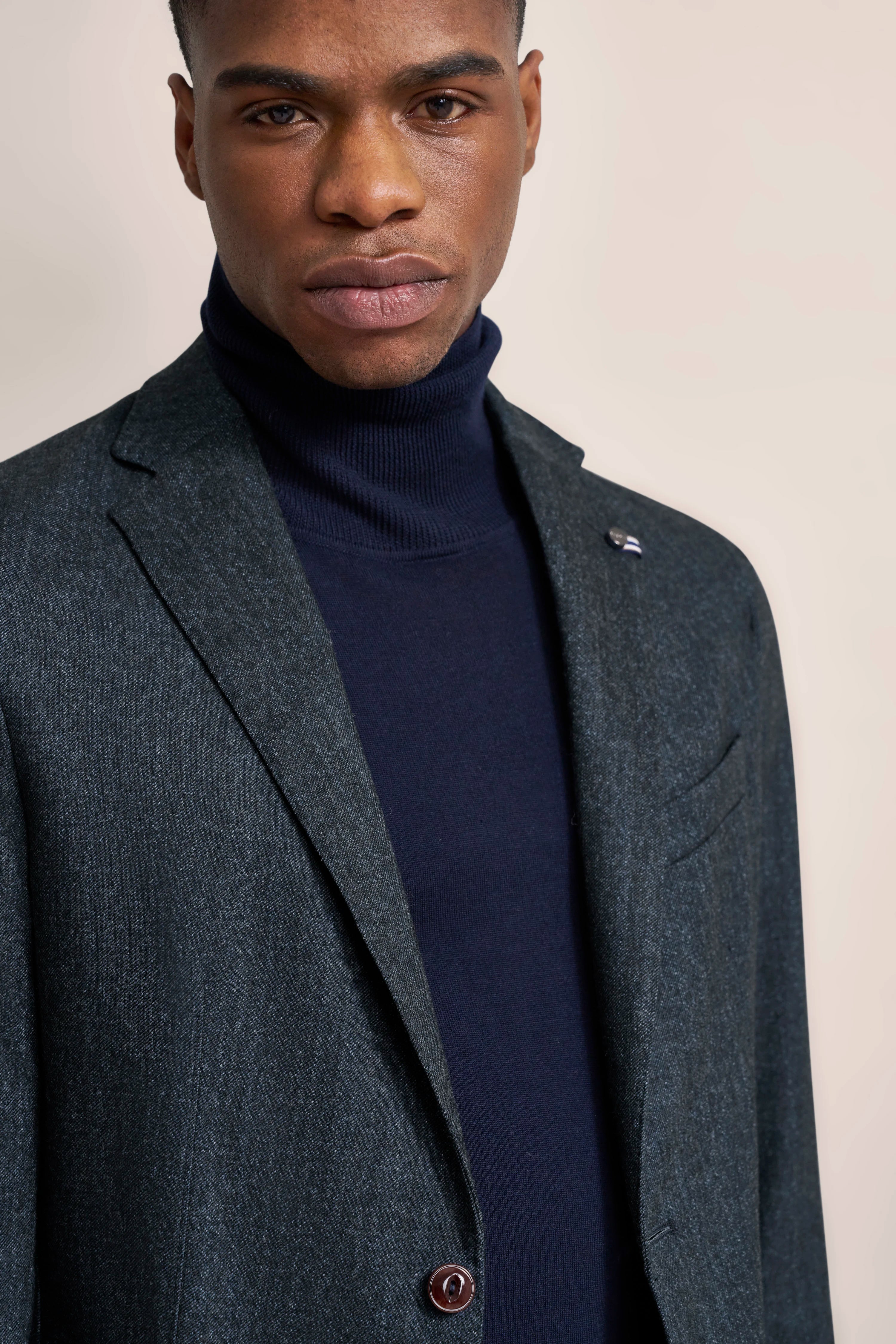 Donkerblauwe blazer en navy coltrui, model poseert elegant.