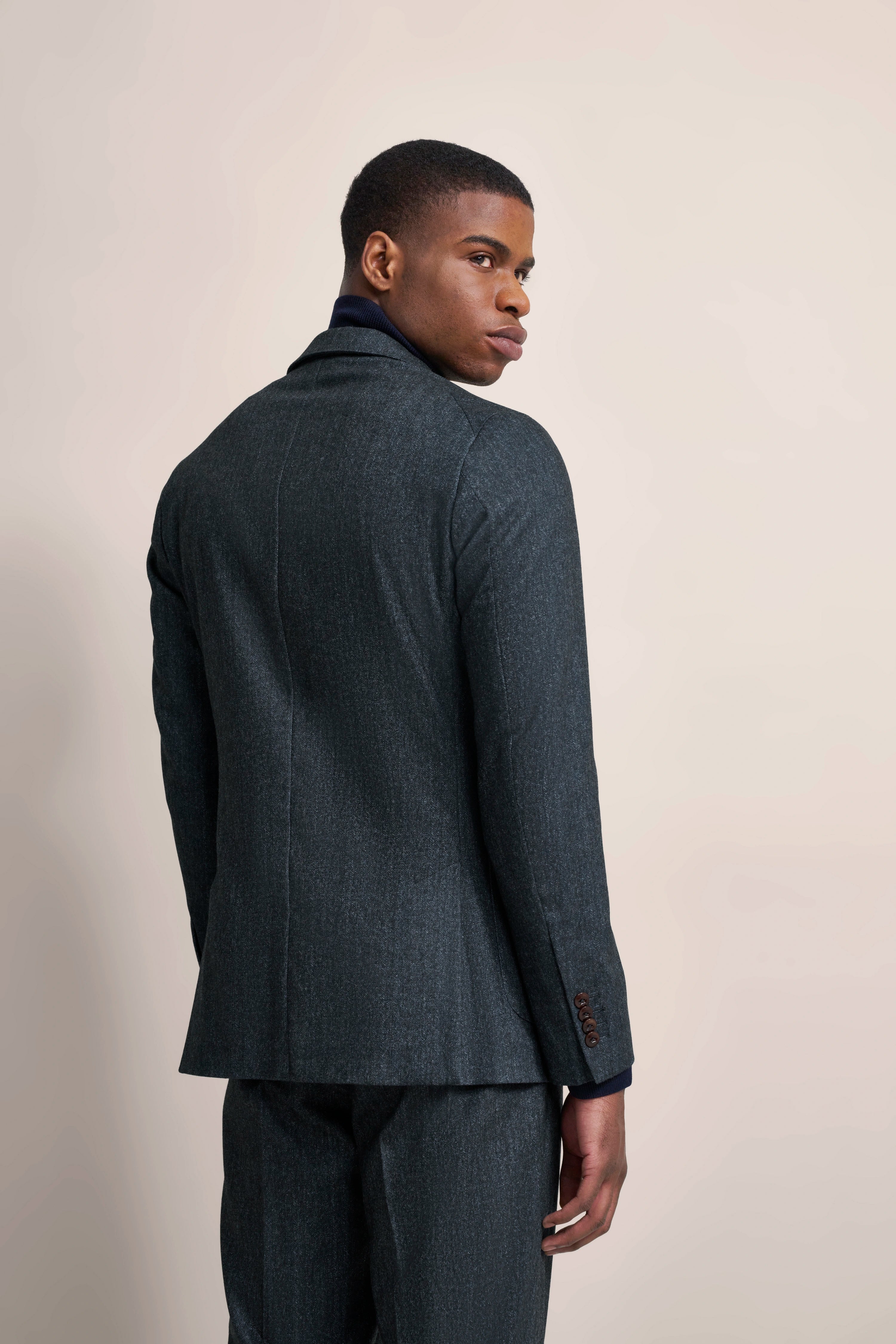 bugatti pak in antraciet, model draait licht, toont rugaanzicht van het elegante outfit.