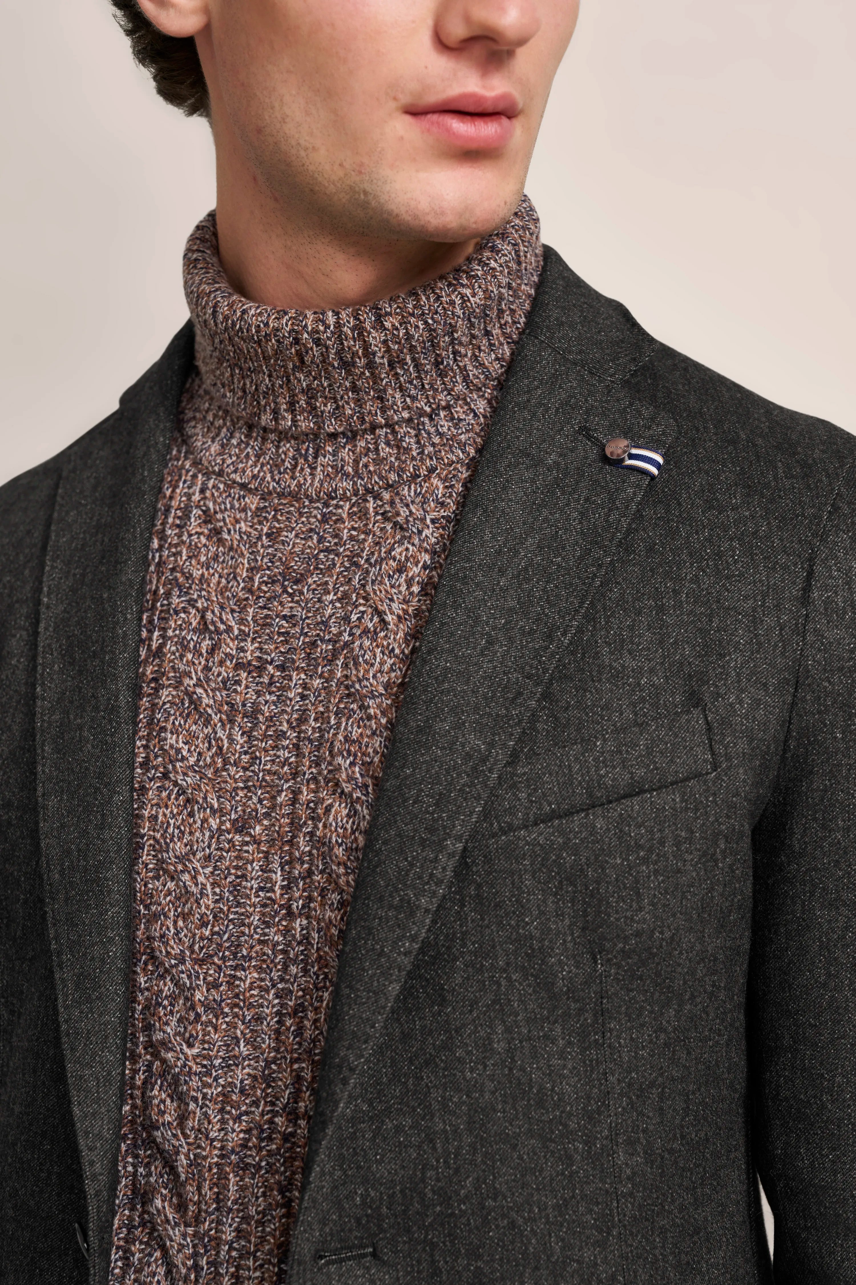 Donkergrijze bugatti blazer met gemêleerde coltrui, model toont ontspannen pose.