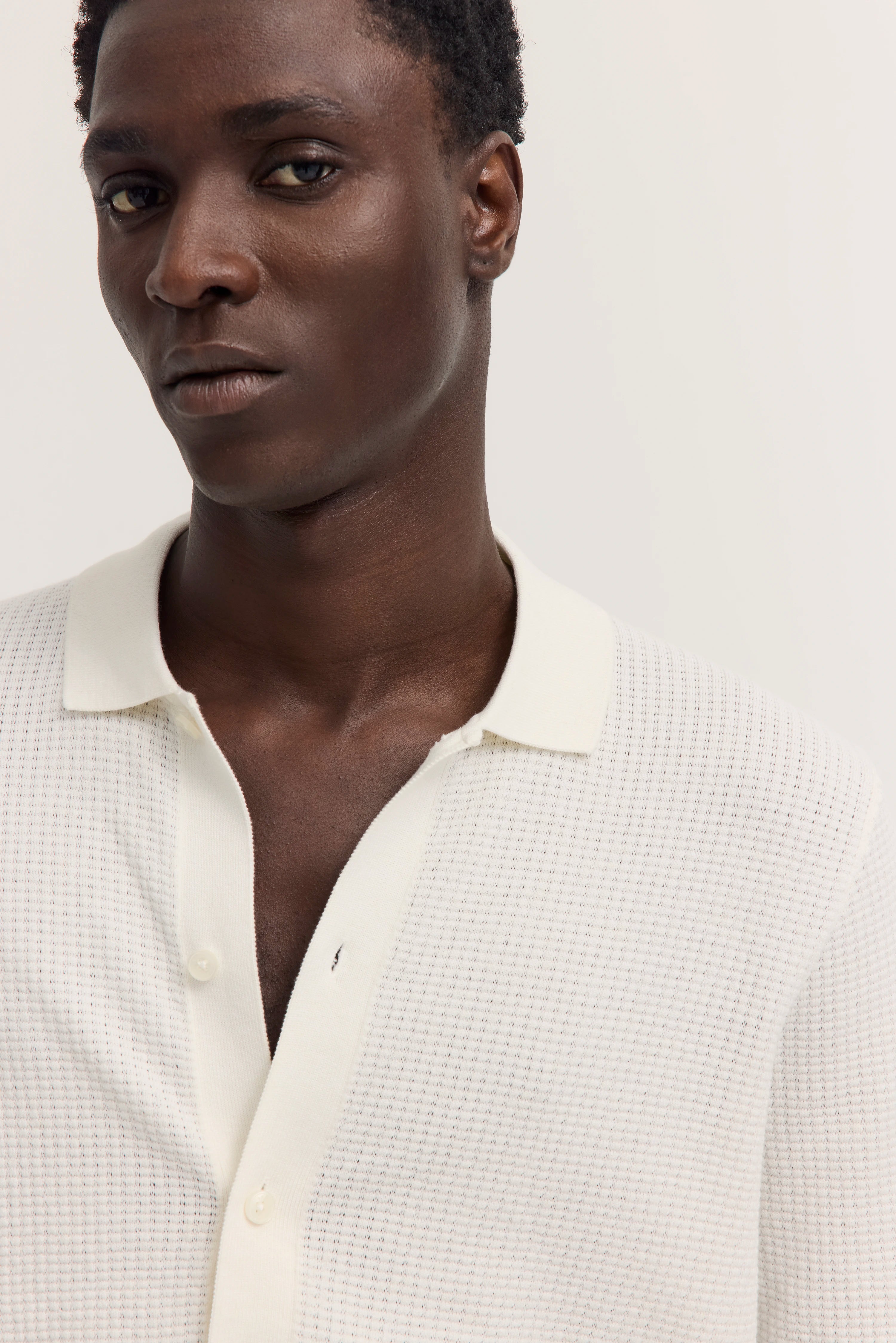 Weiße bugatti Polo mit feiner Struktur, Büstenbild.