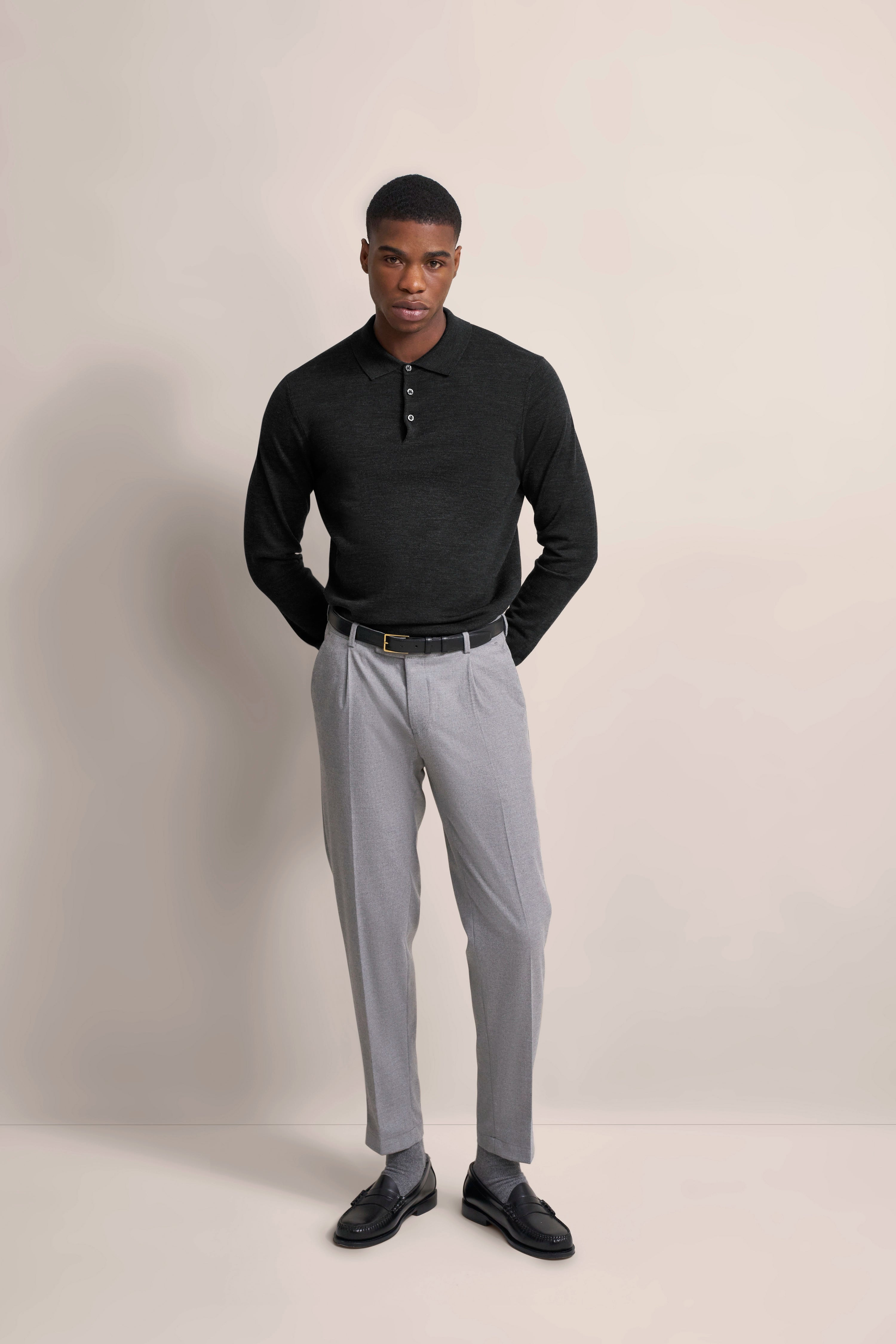 Schwarzer Pullover, graue Hose, schwarzer Gürtel
