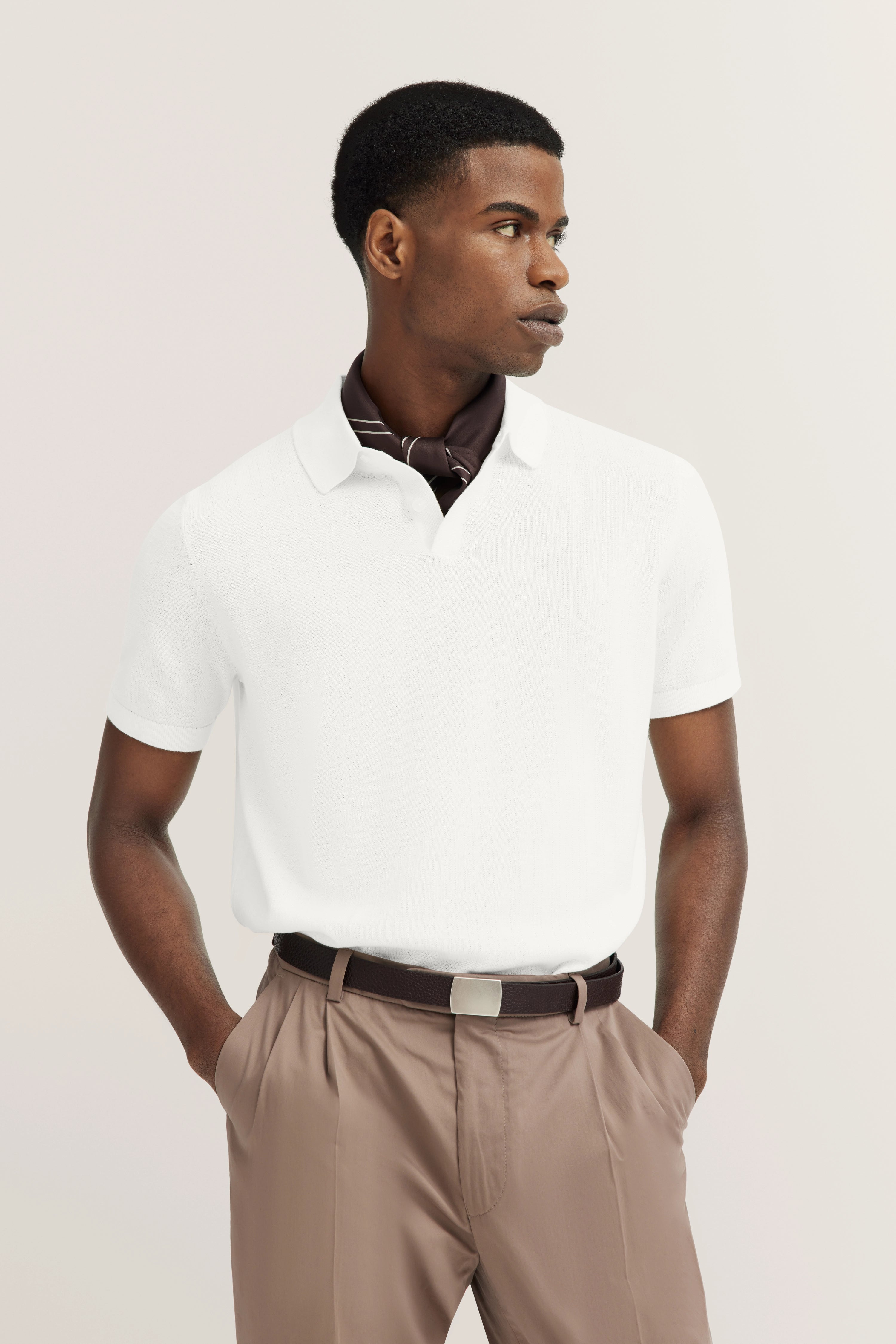 White polo shirt, beige trousers, brown belt