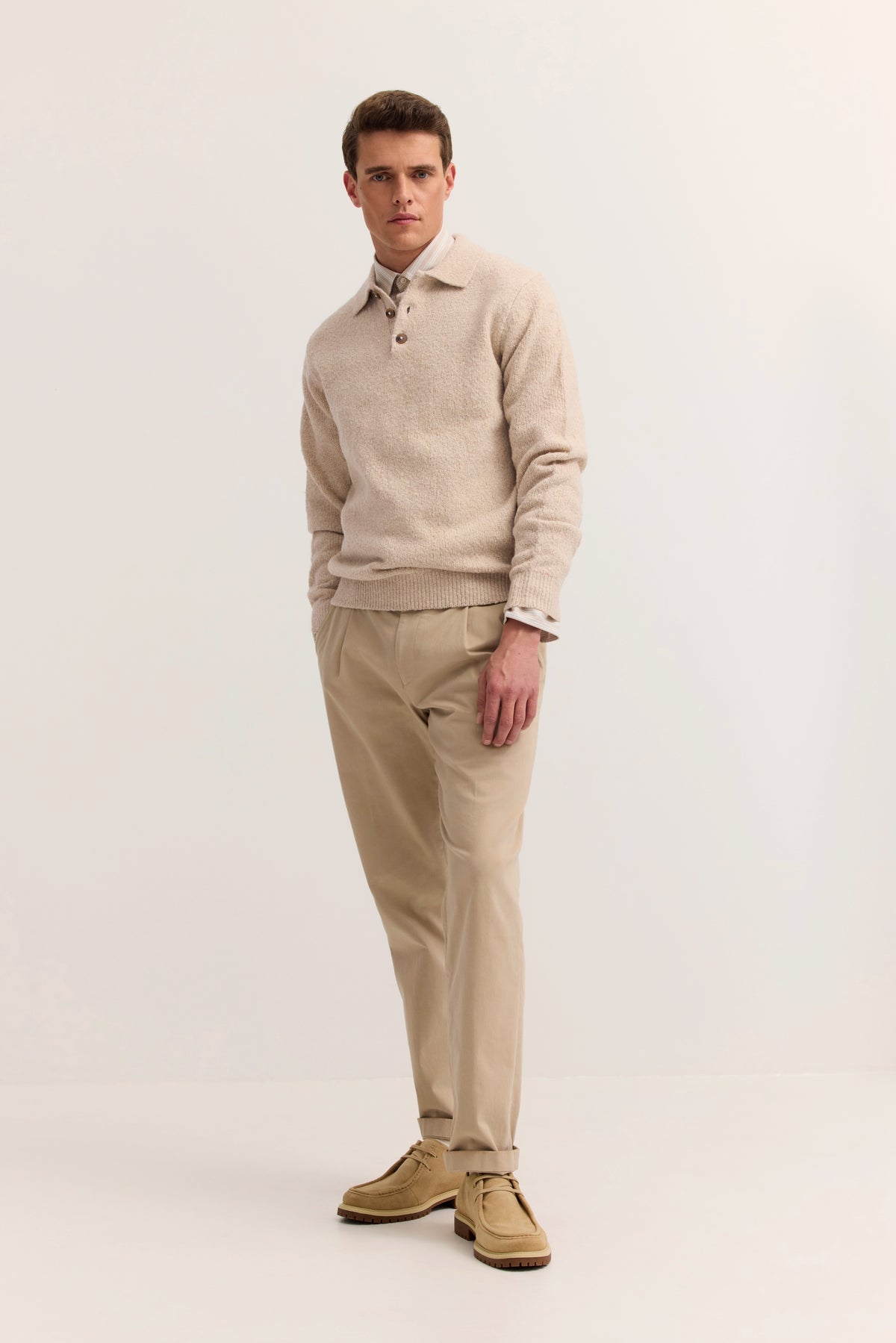 Beige bugatti Pullover und Hose, Modelbild mit lässiger Pose, inspiriert von italienischem Stil.
