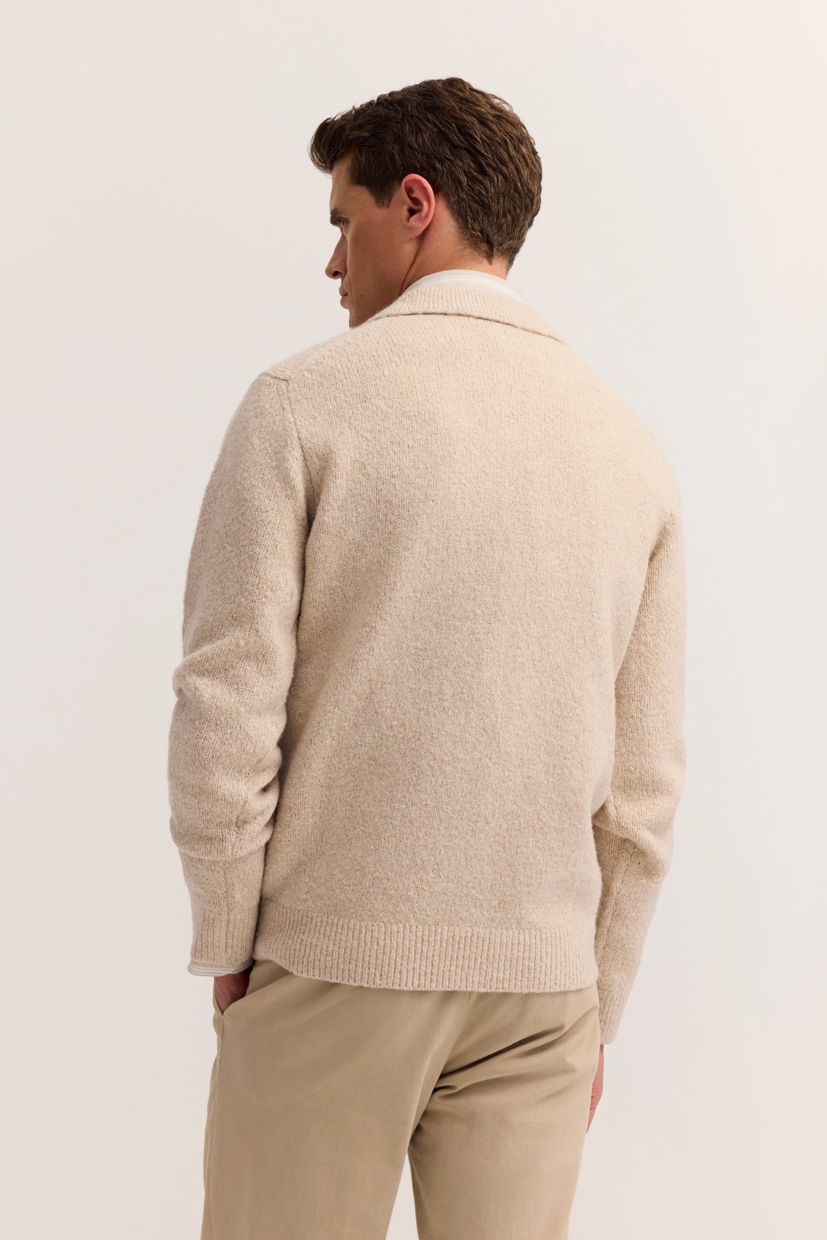 Beigefarbener bugatti Strickpullover, Rückansicht, legeres Modelbild in entspannter Pose.