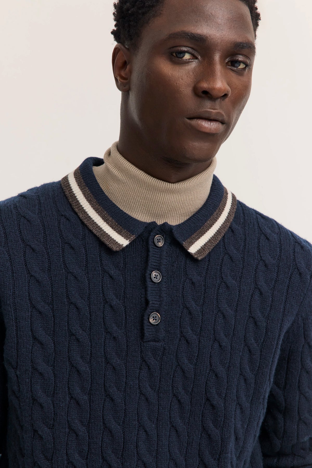 Navy Zopfstrickpullover von bugatti, Beige Hose, Model von hinten, lässige Haltung.