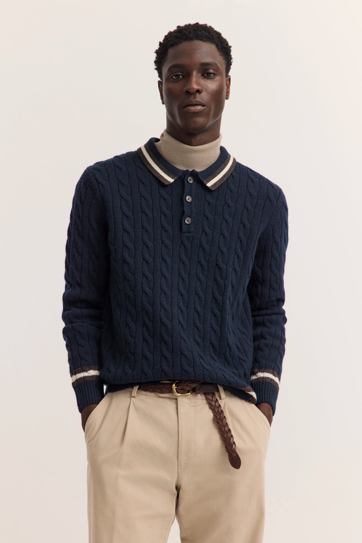 Dunkelblauer Zopfstrickpullover mit beigem Rollkragen, Chinos