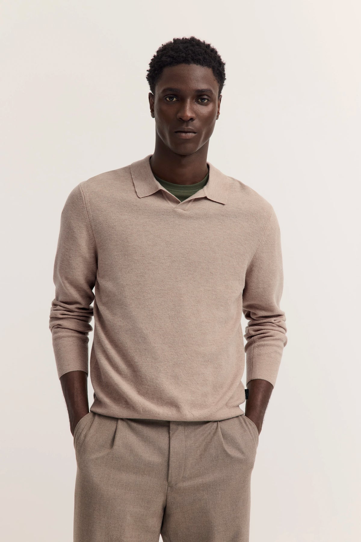 Model in beige bugatti Pullover und Hose, legeres Posing, stilvoll und zeitlos.