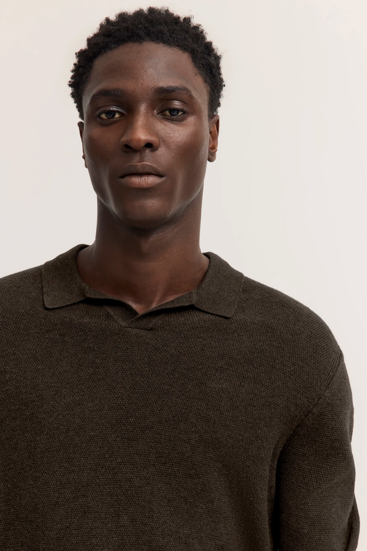 Büstenbild: Model mit dunkelbraunem, texturiertem bugatti Pullover mit Kragen.