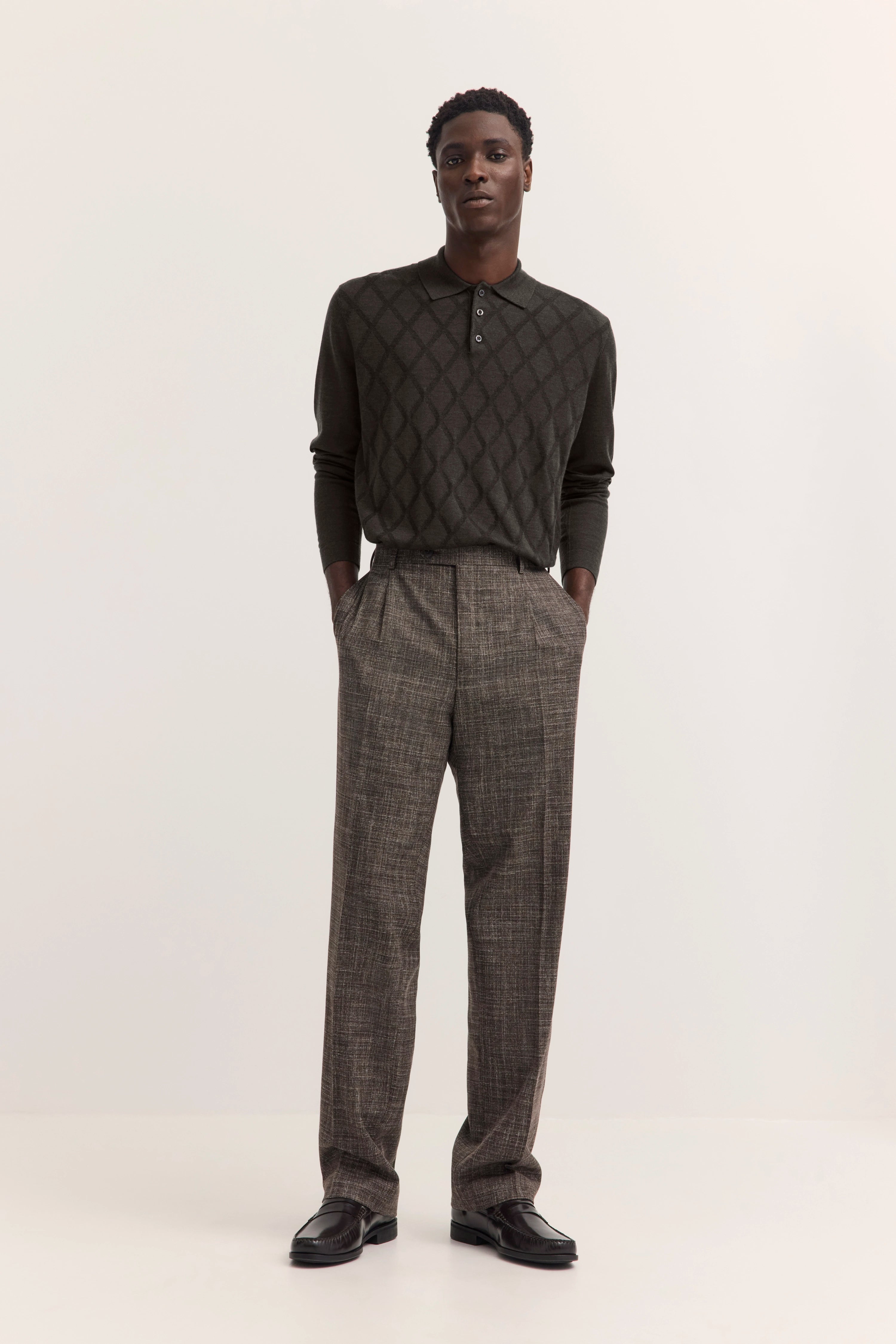 "Dunkler Pullover mit Rautenmuster, graue Hose