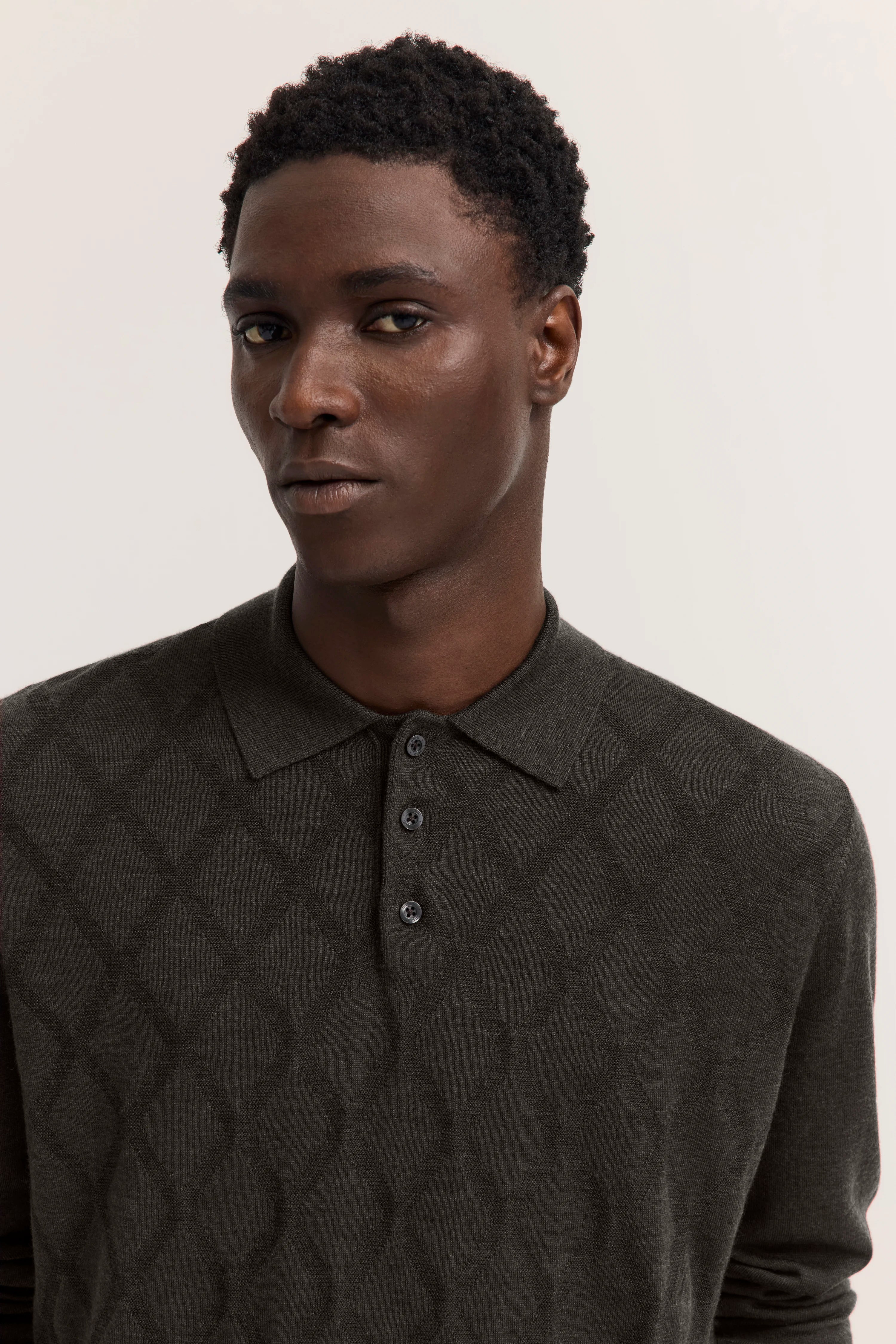 Dunkelgrauer Pullover mit Rautenmuster, Modelbild, neutraler Blick, eleganter Stil von bugatti.