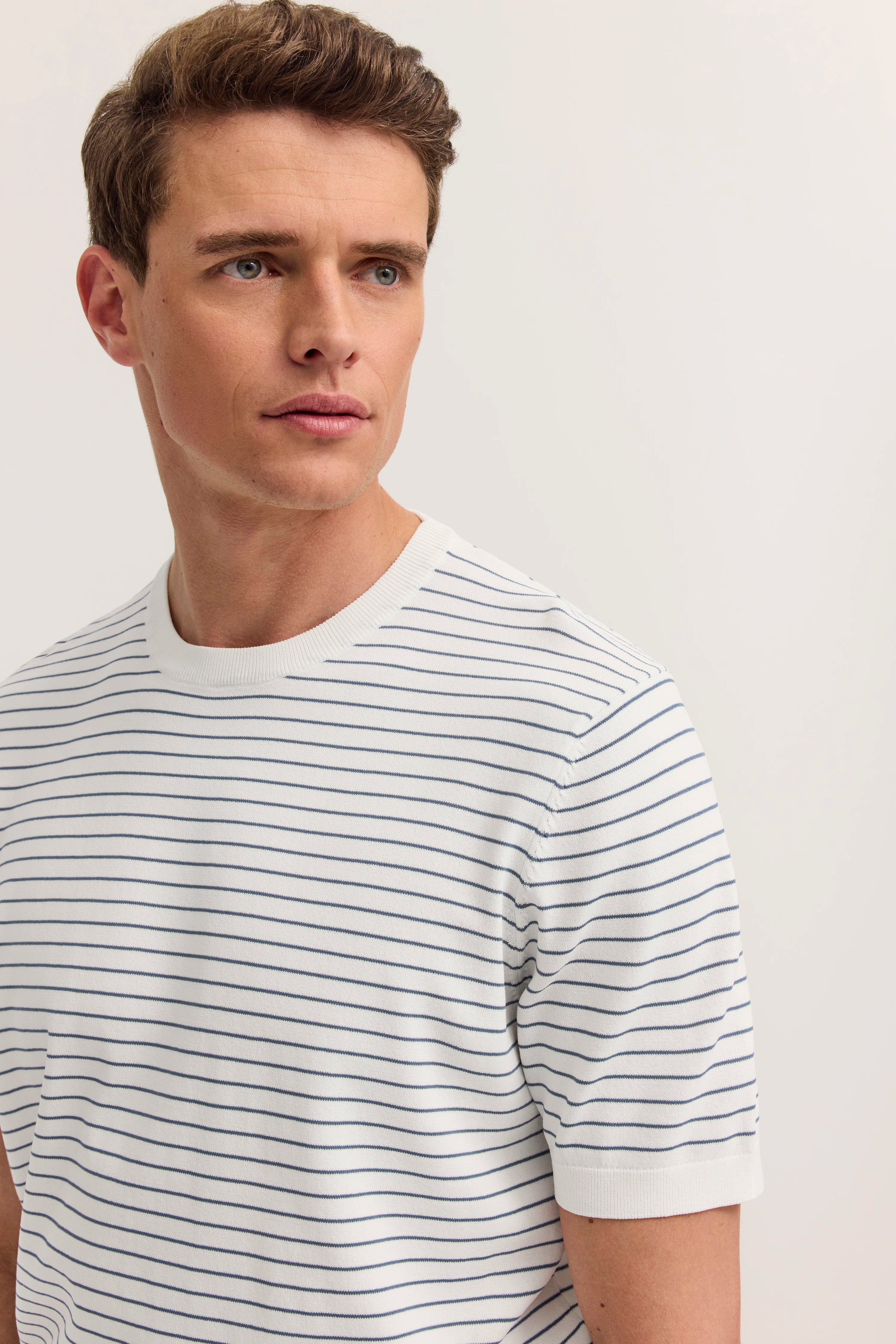 Weißes, gestreiftes T-Shirt von bugatti auf Model im Halbprofil.