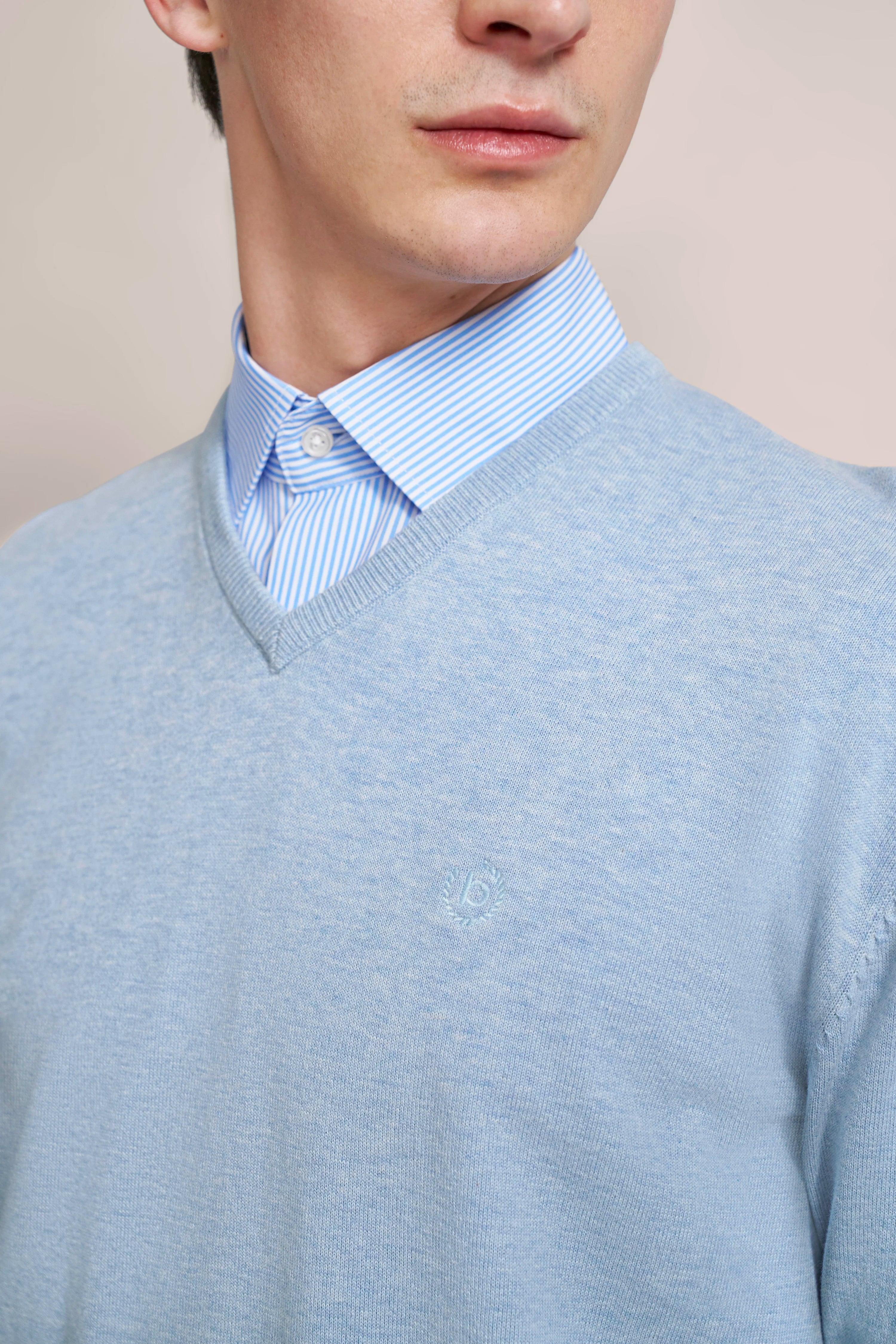 Büstenbild mit hellblauem bugatti-Pullover und gestreiftem Hemd. Eleganz und Stil vereint.