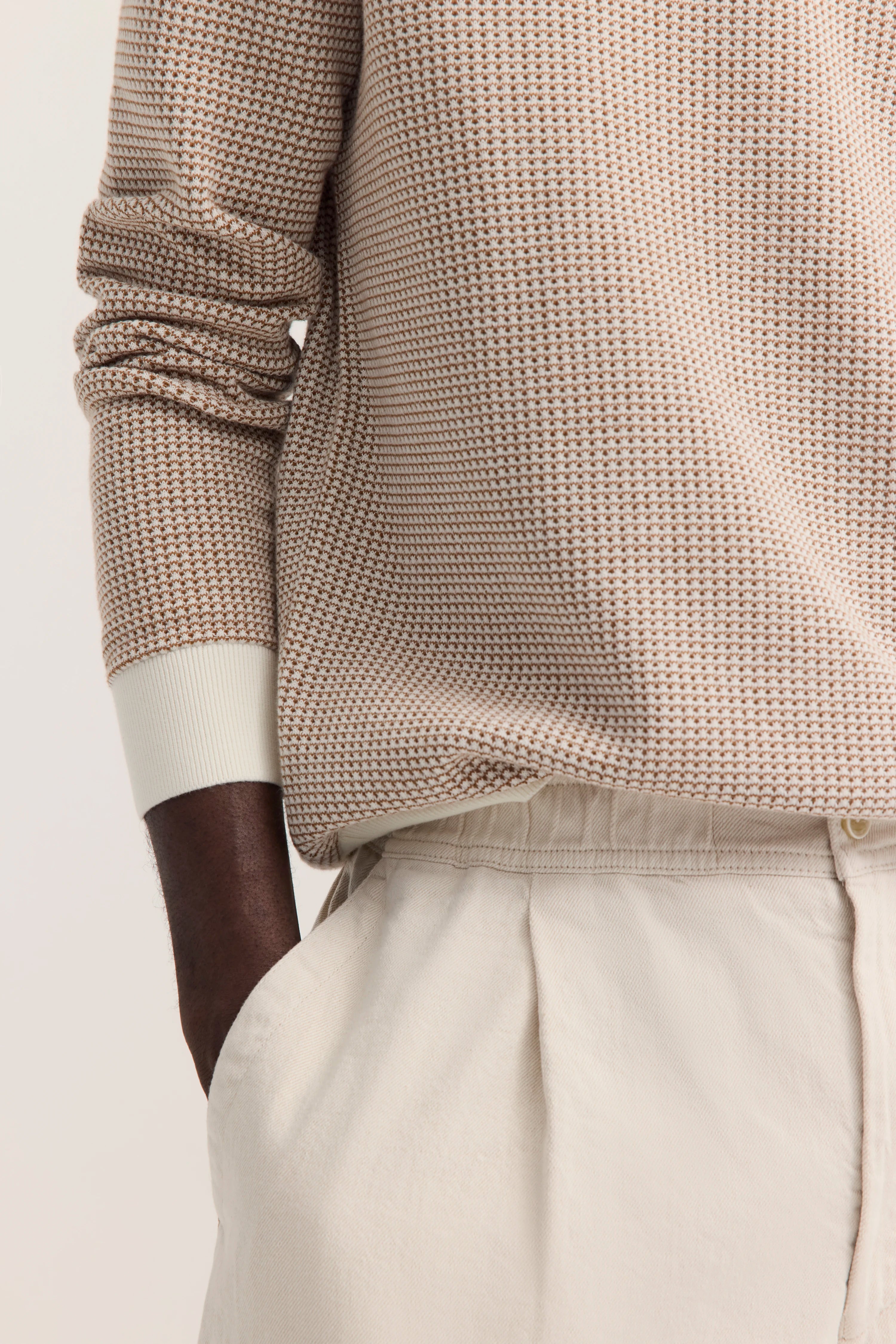 Beigefarbener Strickpullover und helle Hose in legerem Büstenbild von bugatti.