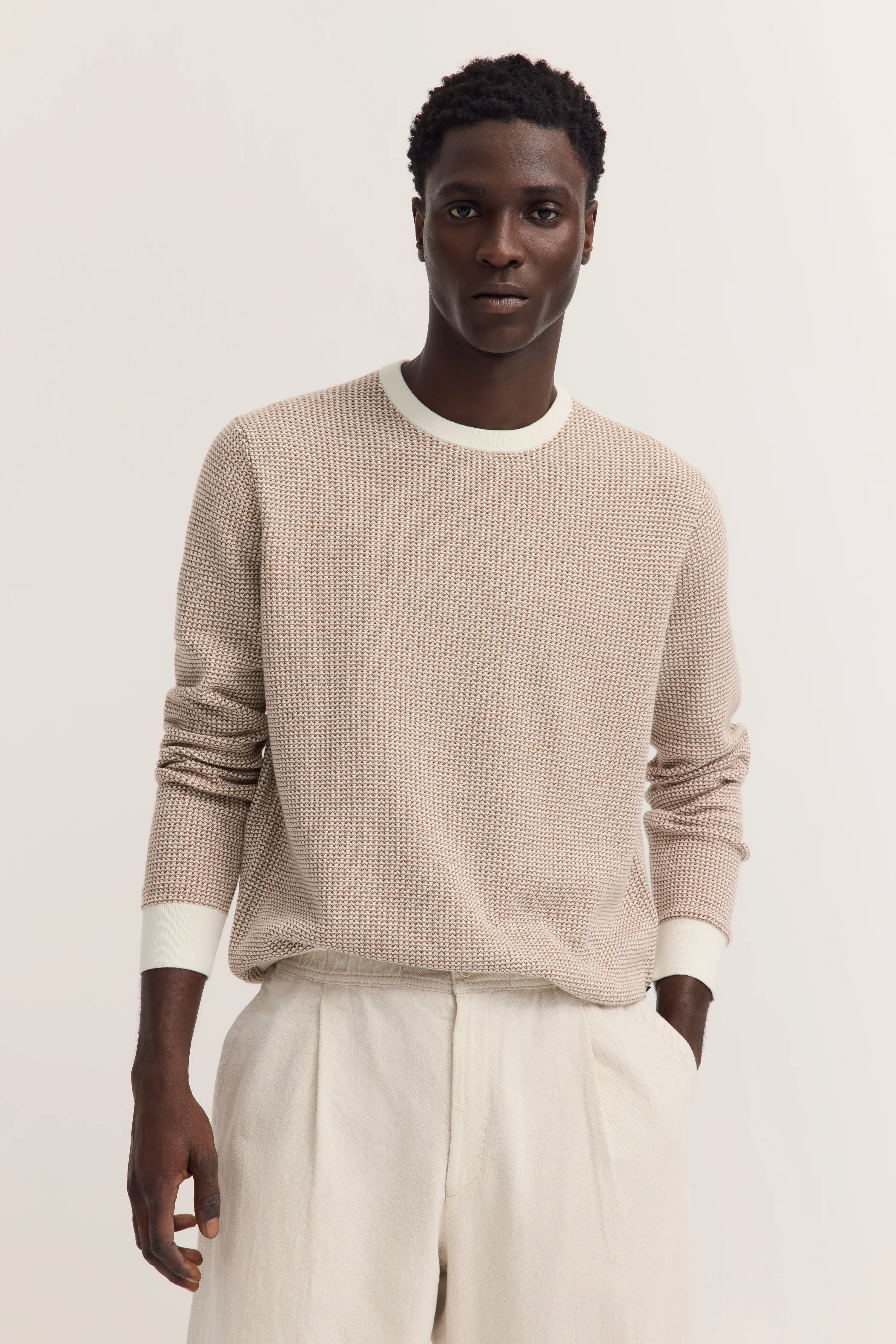 Bugatti Modelbild, cremefarbener Pullover, entspannte Pose.