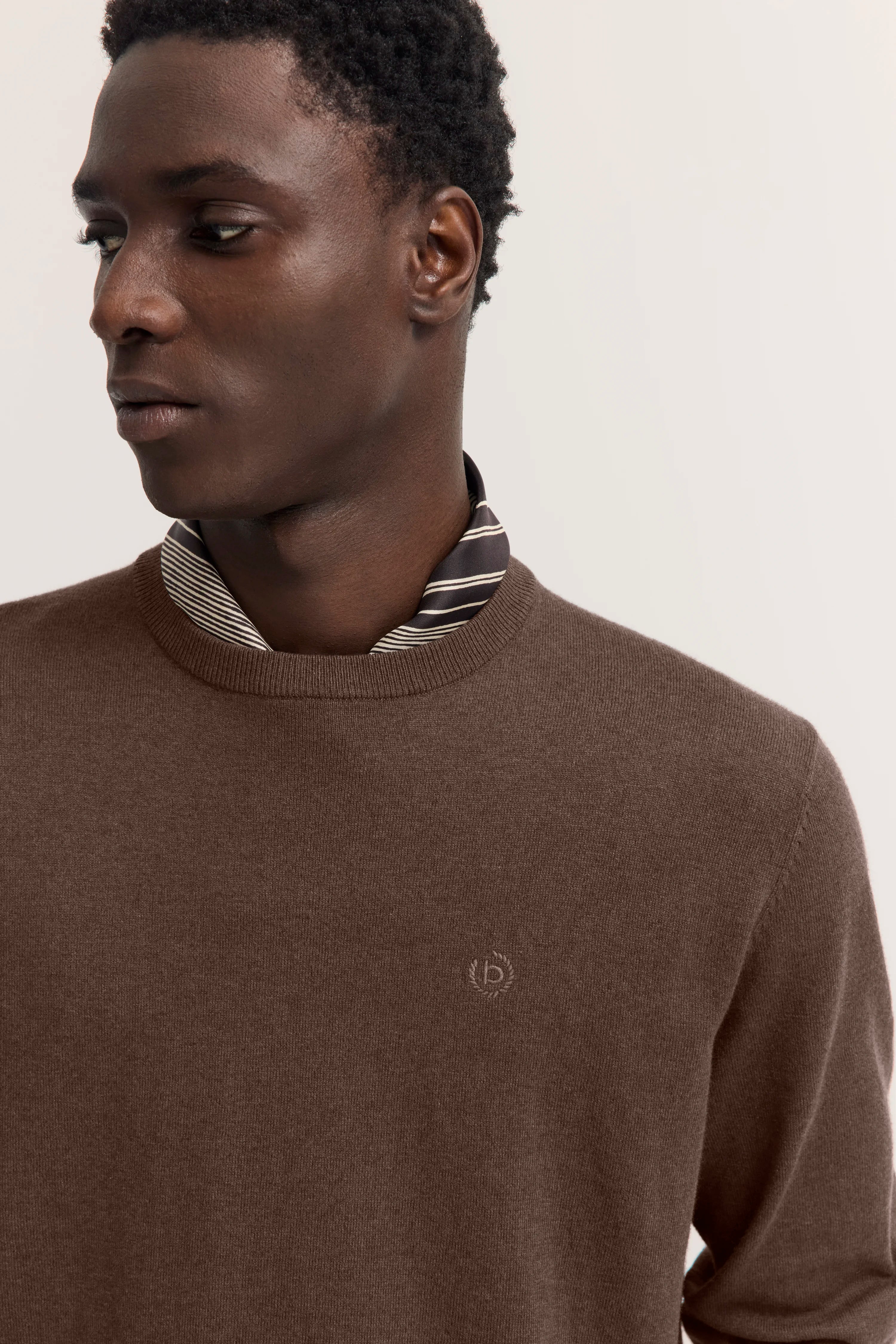 Bugatti Modelbild, Pullover braun, gestreiftes Hemd darunter, seitliches Posing.