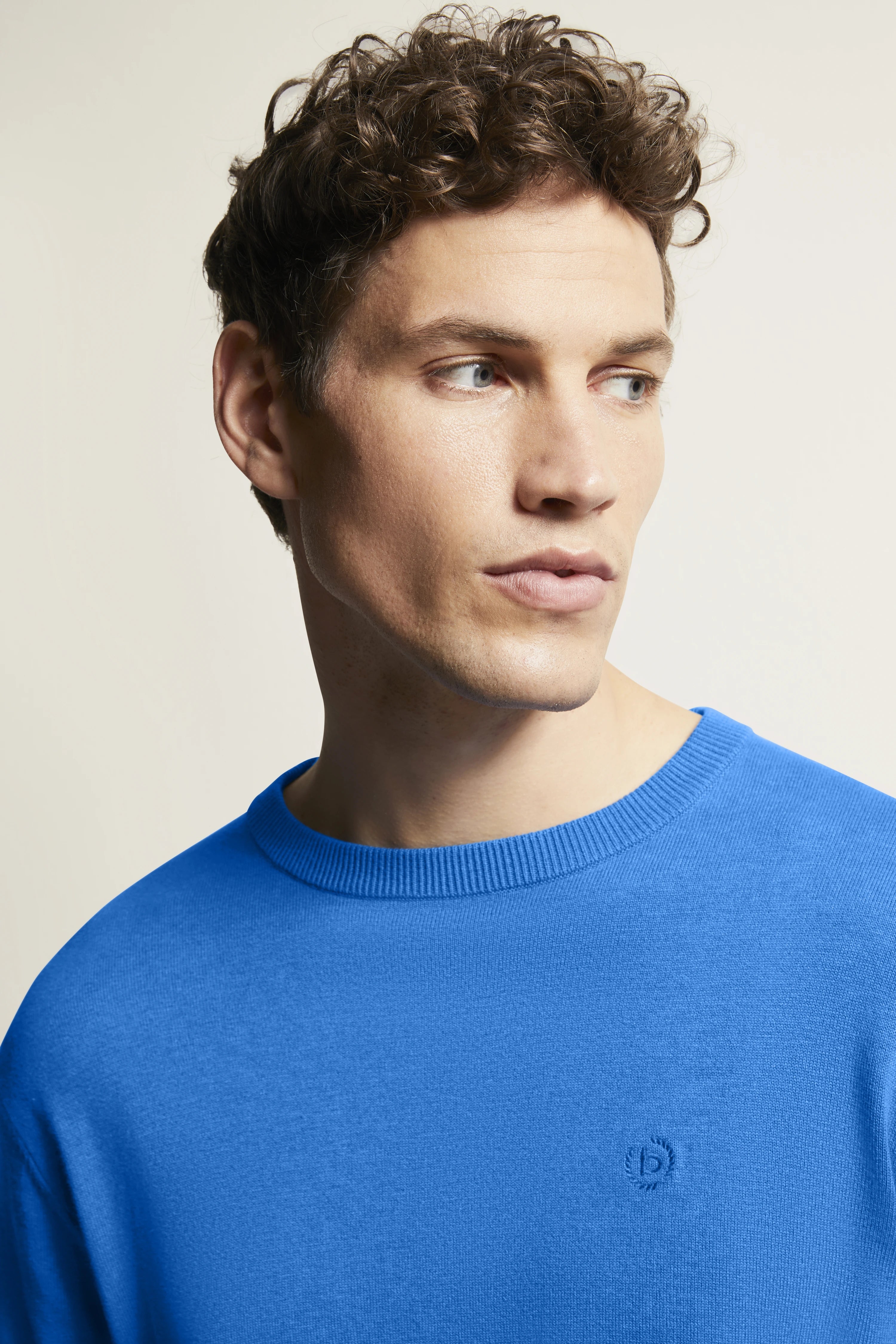 Bugatti Model in blauem Pullover, legeres Porträt, entspanntes Posing.