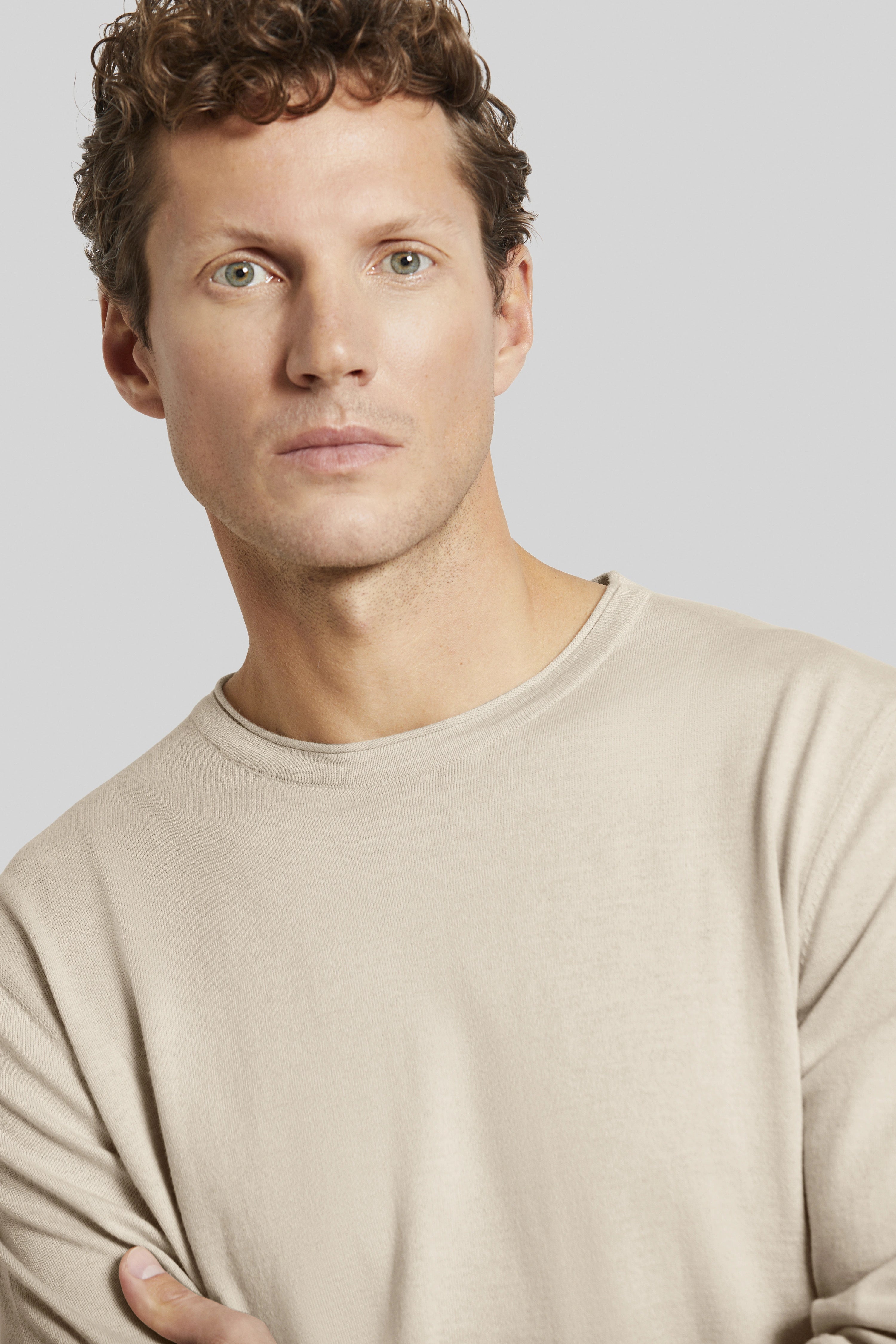 bugatti Modelbild, legeres Posing, beige Langarmshirt, stilvoll und zeitlos.