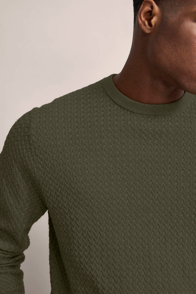 Olivgrüner Pullover mit Zopfmuster, Büstenbild, bugatti Stil, Gelassenheit Italiens inspiriert.