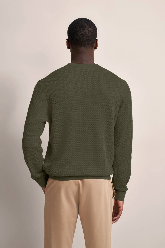 bugatti Modelbild: Grüner Pullover mit Strukturmuster, beige Hose, Rückansicht, entspanntes Posing.