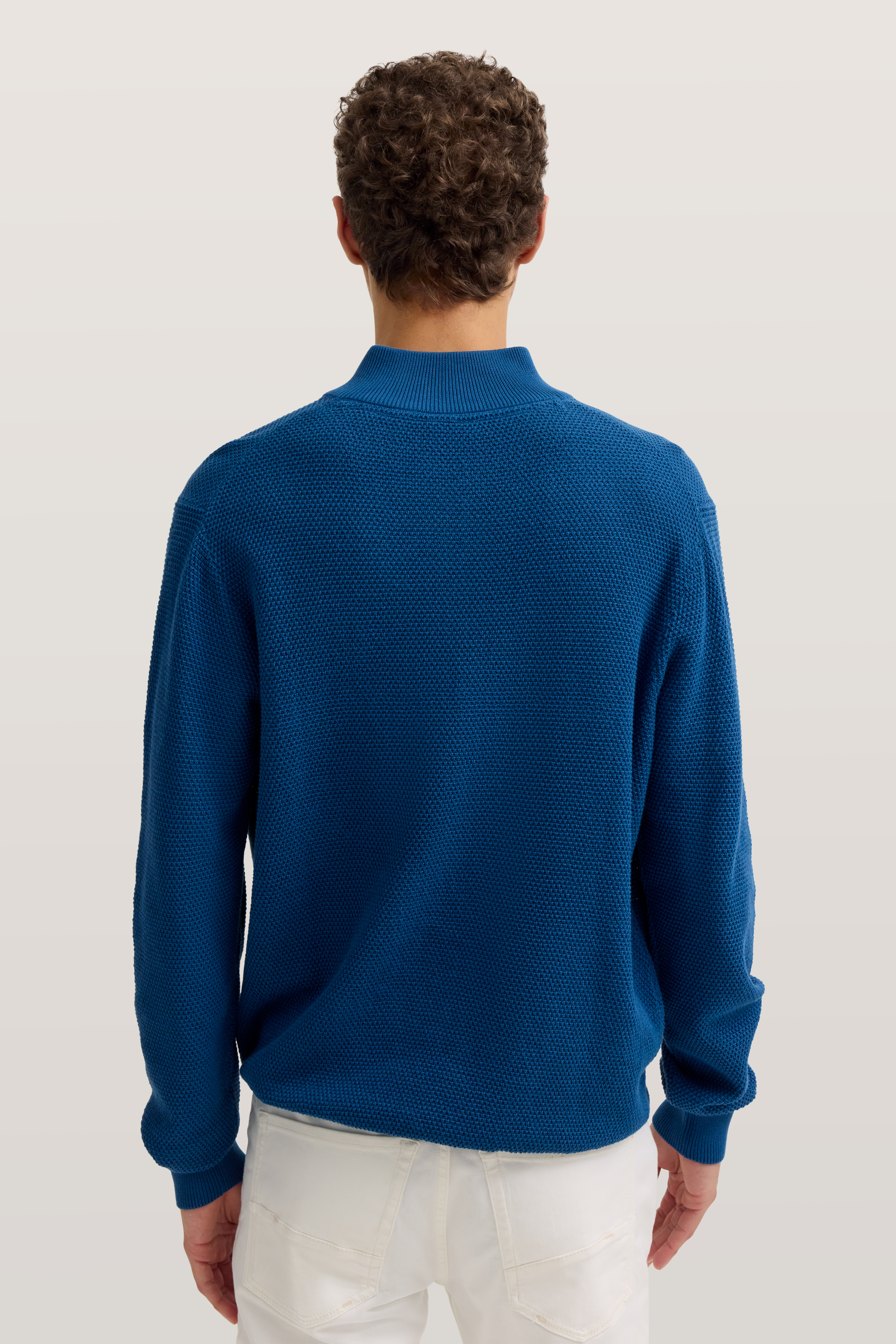 Blauer Strickpullover von bugatti, Rückansicht, legeres Modelbild, kombiniert mit weißen Hosen.