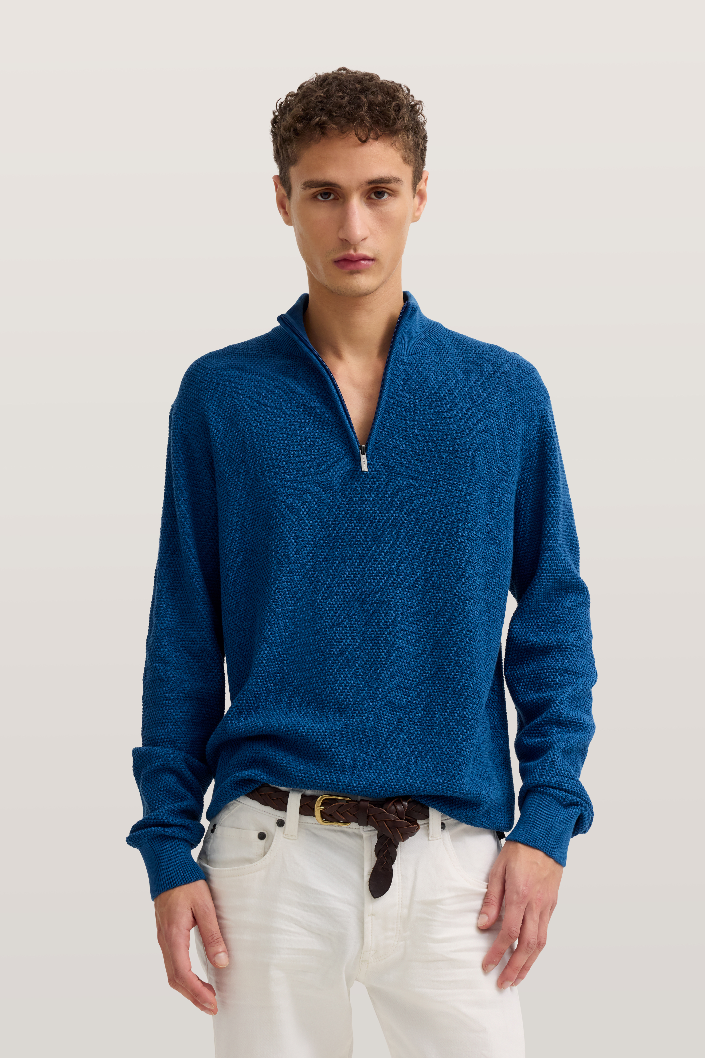 Blauer bugatti Pullover, weißer Jeans, Modelbild, entspanntes Posing.