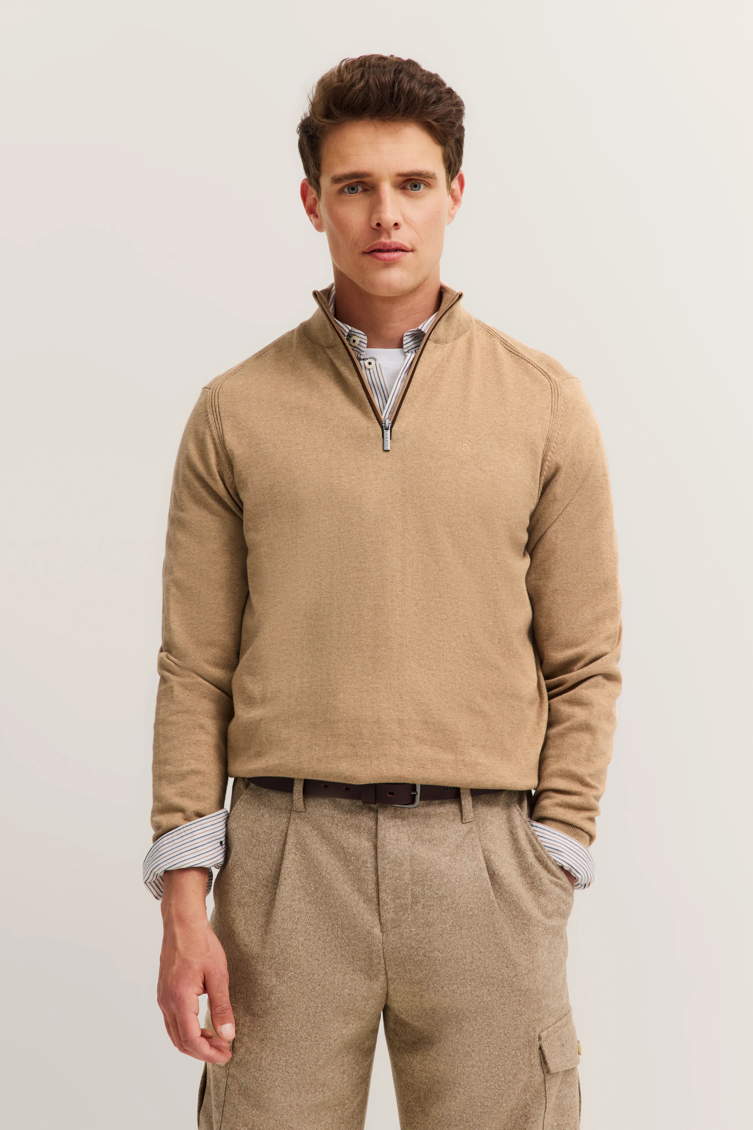 Beigefarbener bugatti Pullover und Hose, Modelbild, entspannte Haltung.