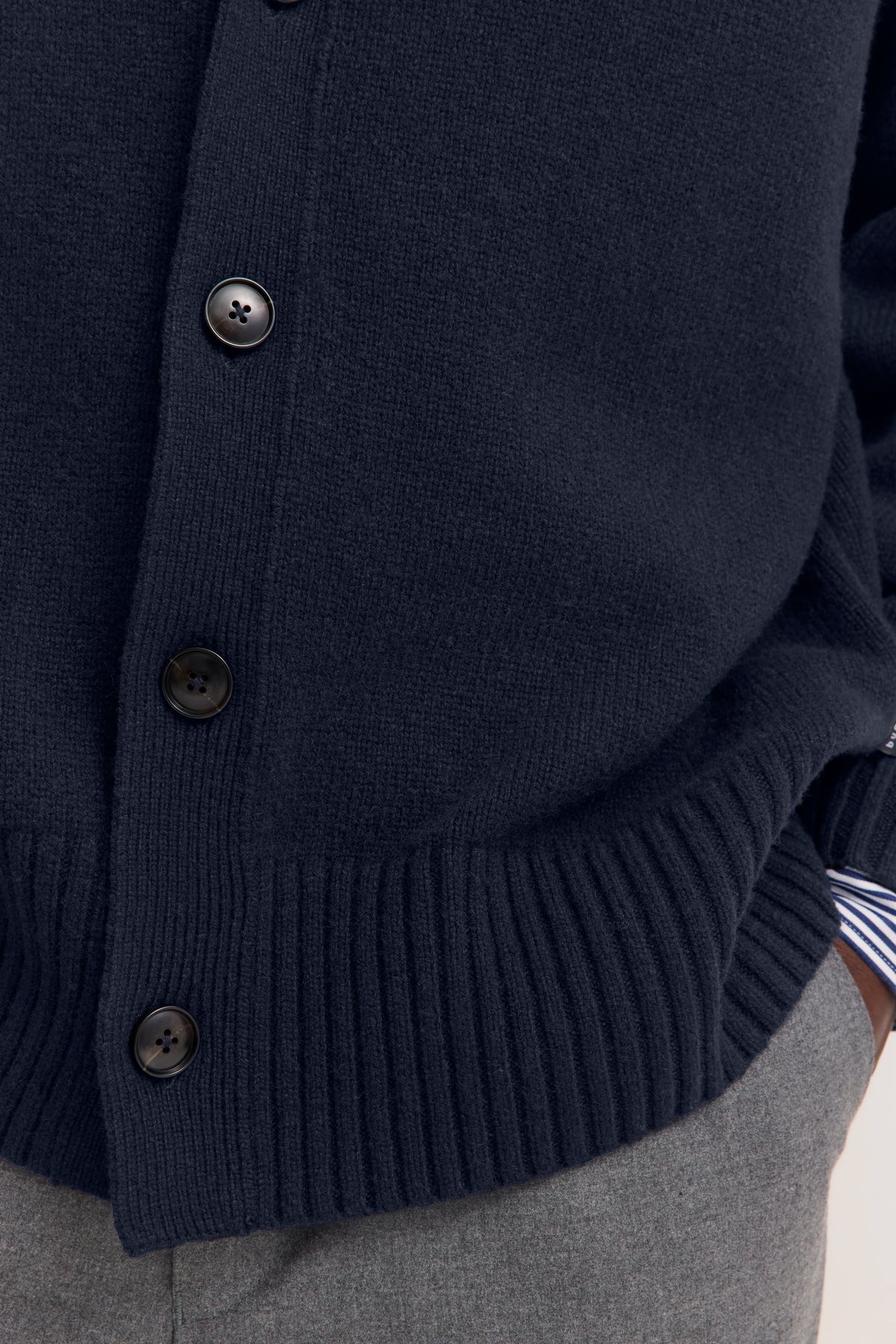 Dunkelblauer bugatti Cardigan mit Knöpfen, Detailaufnahme, kombiniert mit grauer Hose.