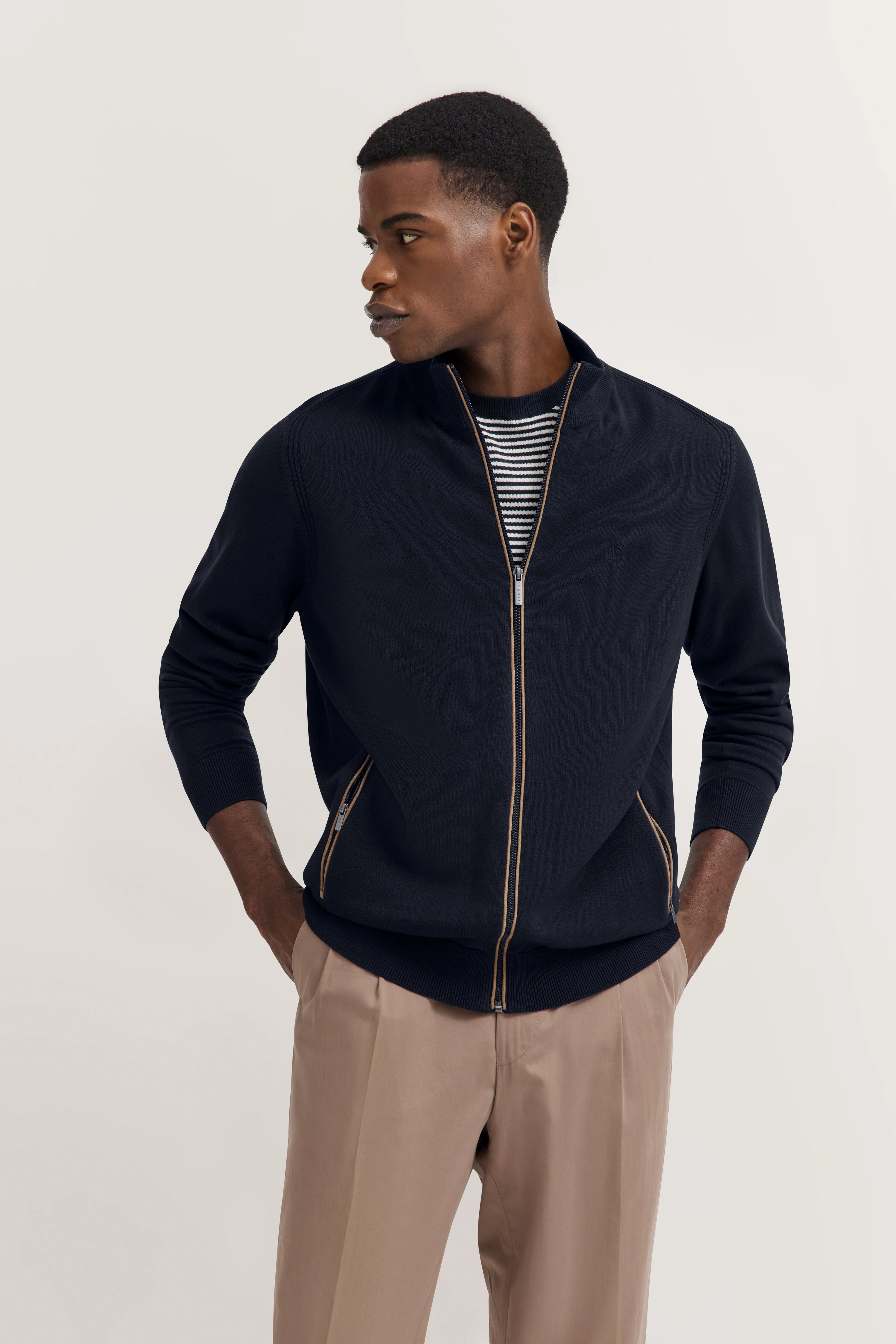 Model in marineblau jack met gestreept shirt, beige broek