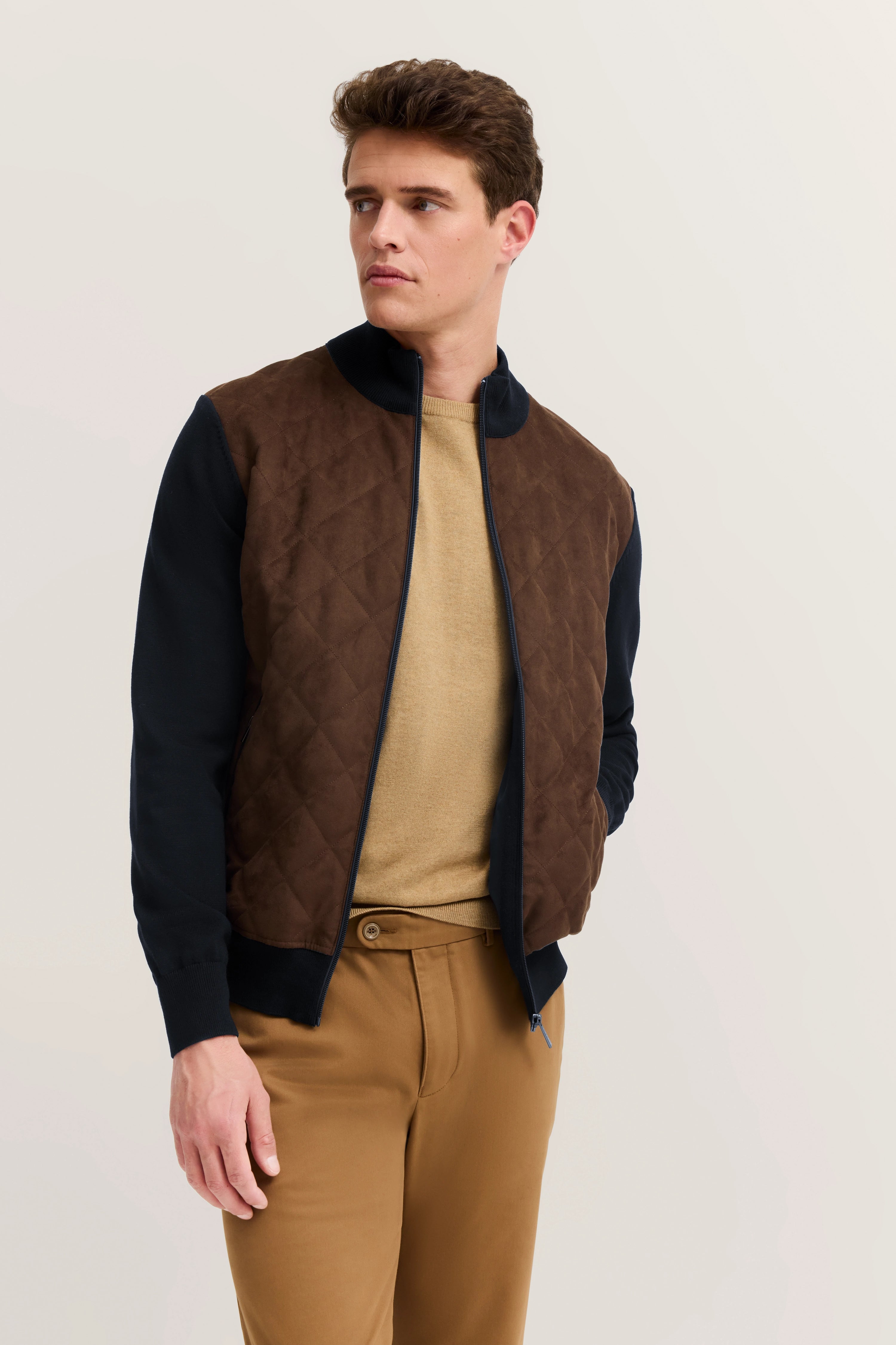 Braune Steppjacke, navy Ärmel, beigefarbener Pulli, camel Chinos