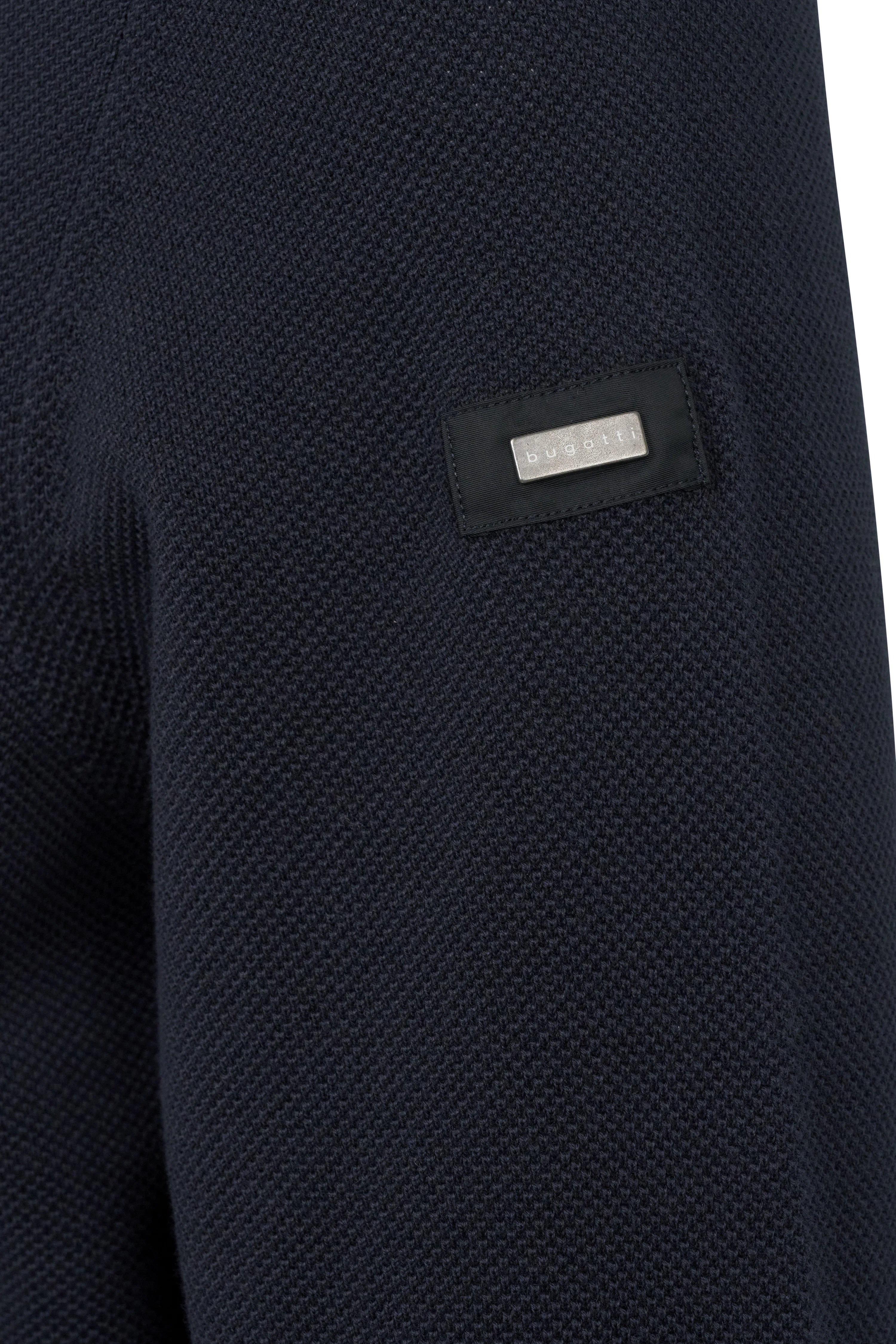 Dunkelblauer Strickstoff mit bugatti-Logo, Detailaufnahme.