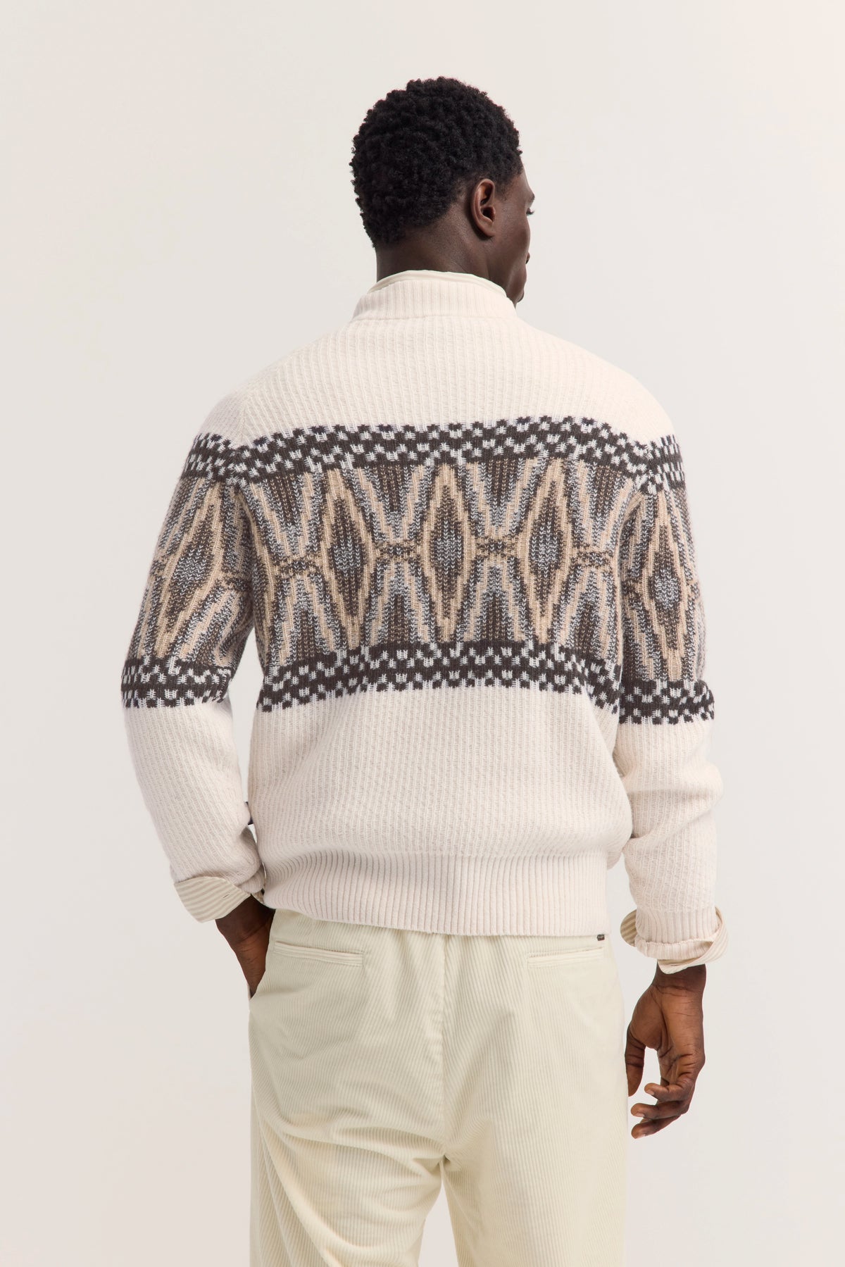 Herren-Strickjacke mit geometrischem Muster in Beige und Braun, Modellbild von hinten.