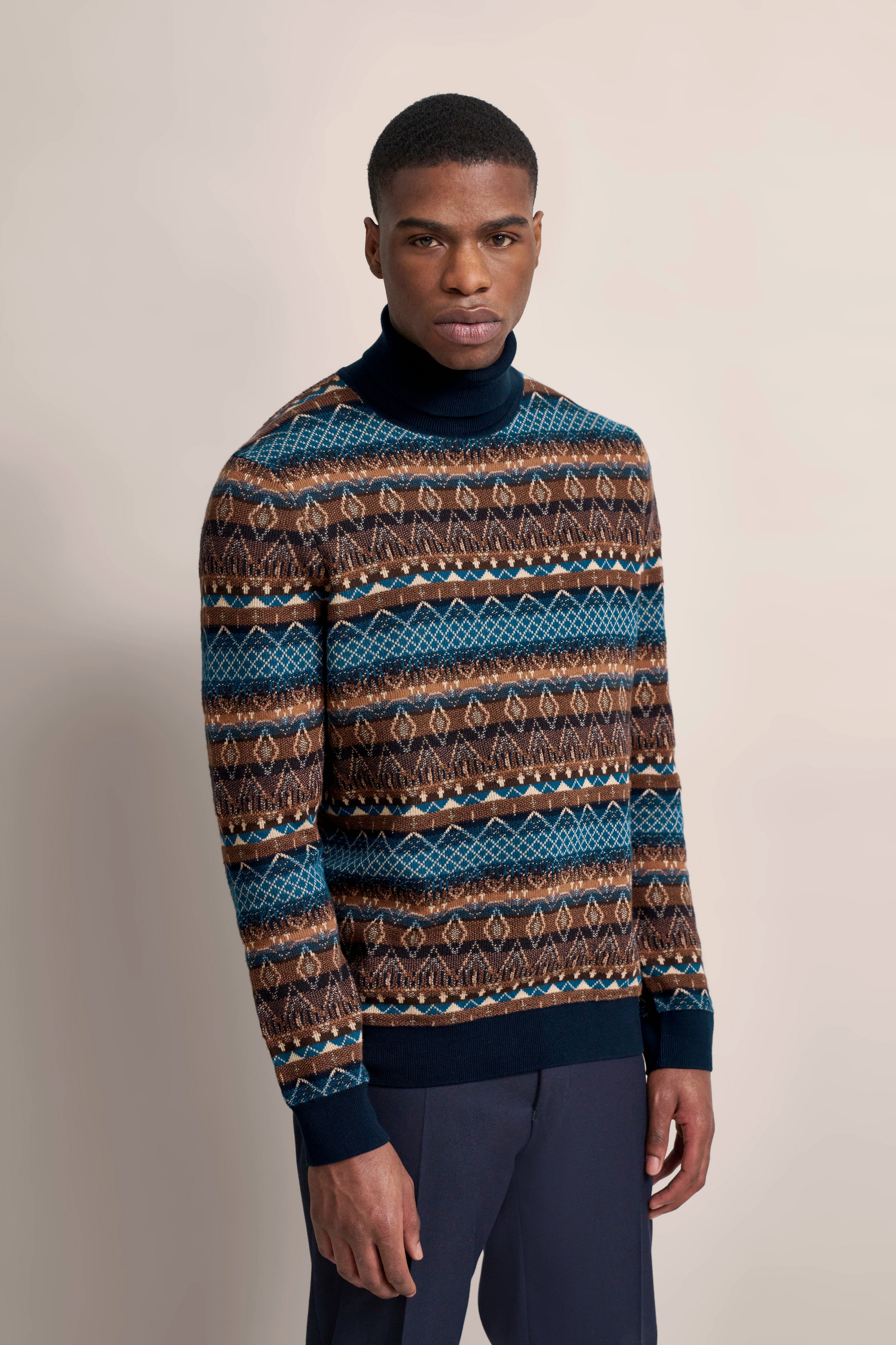 Modelbild in bugatti Pullover mit blau-braunem Muster, lässiges Posing, elegante Ästhetik.