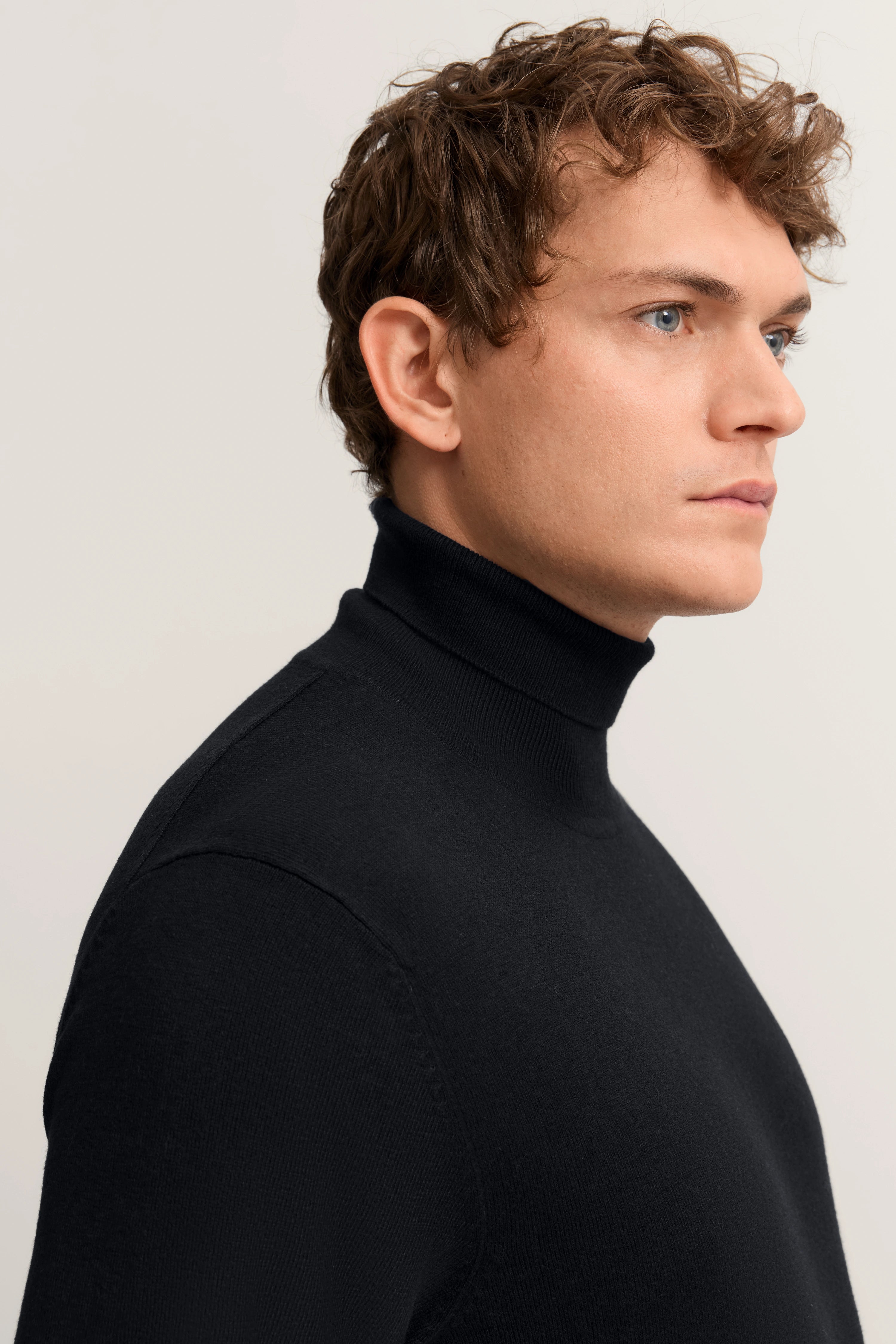 Schwarzer Rollkragenpullover von bugatti auf Büstenbild, seitliches Profil.