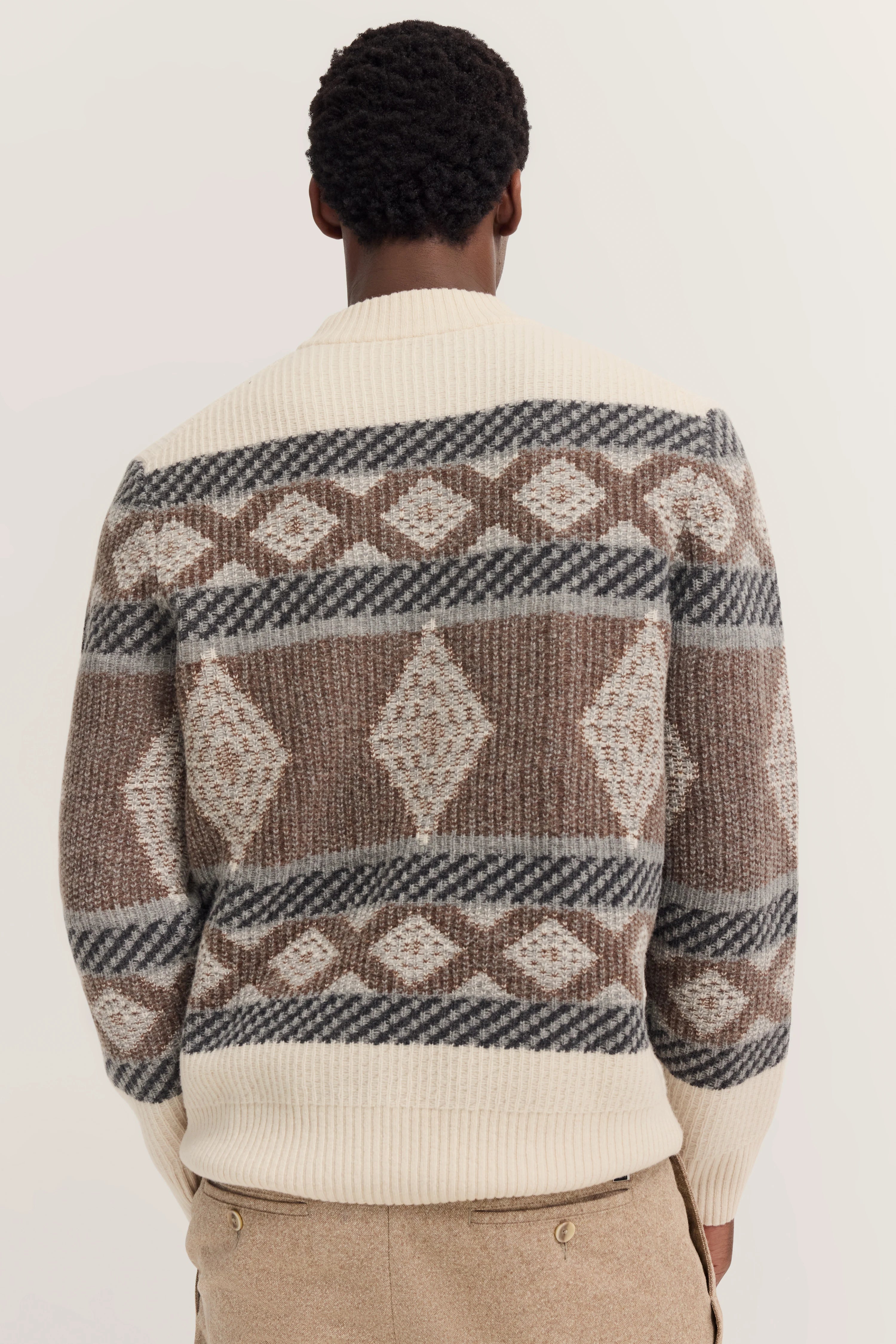 Beige, grijze, bruine gebreide trui met geometrisch patroon, achterkant model.